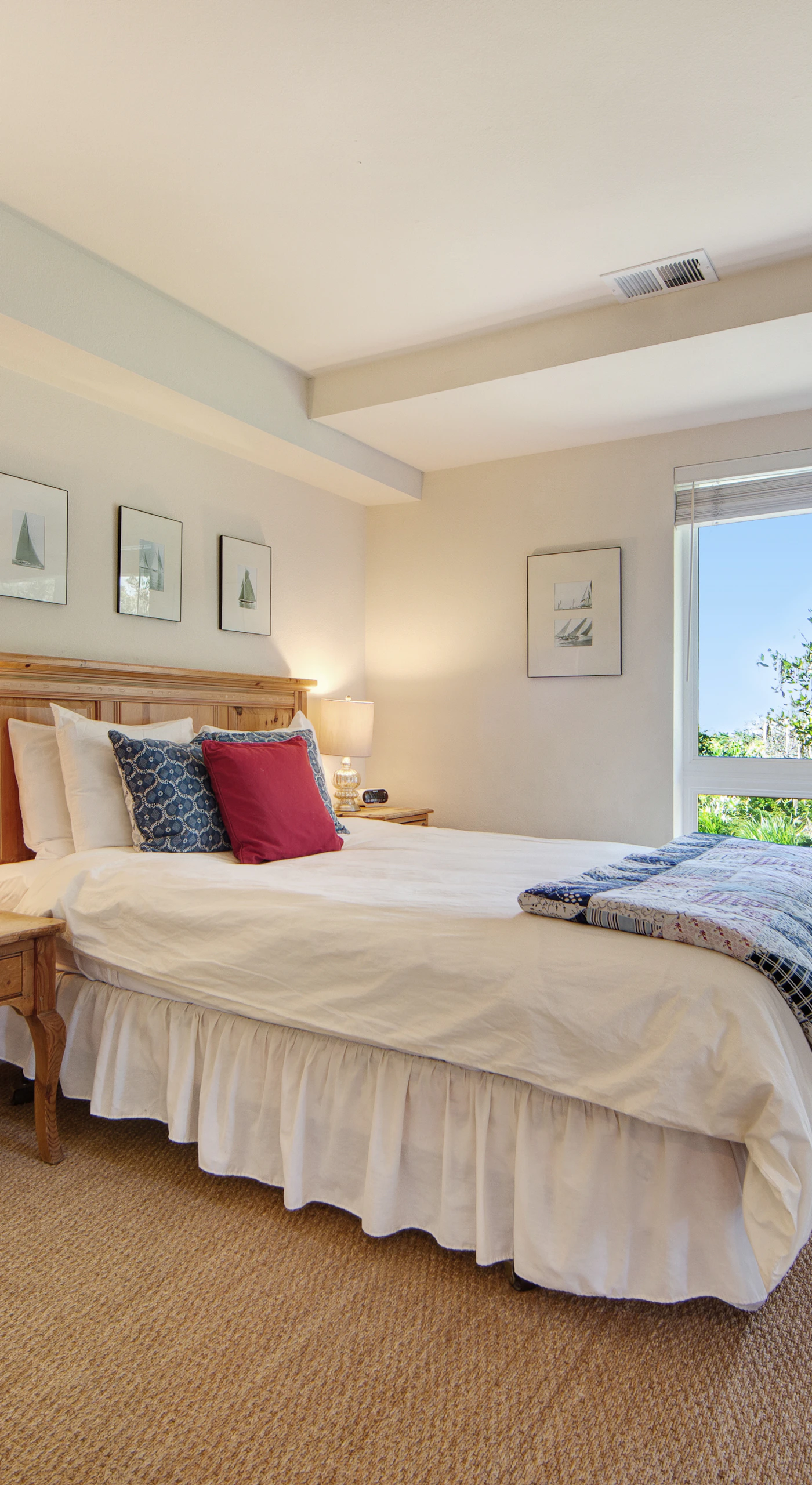 Drift off in this serene queen bedroom with a picture window framing lush garden views.