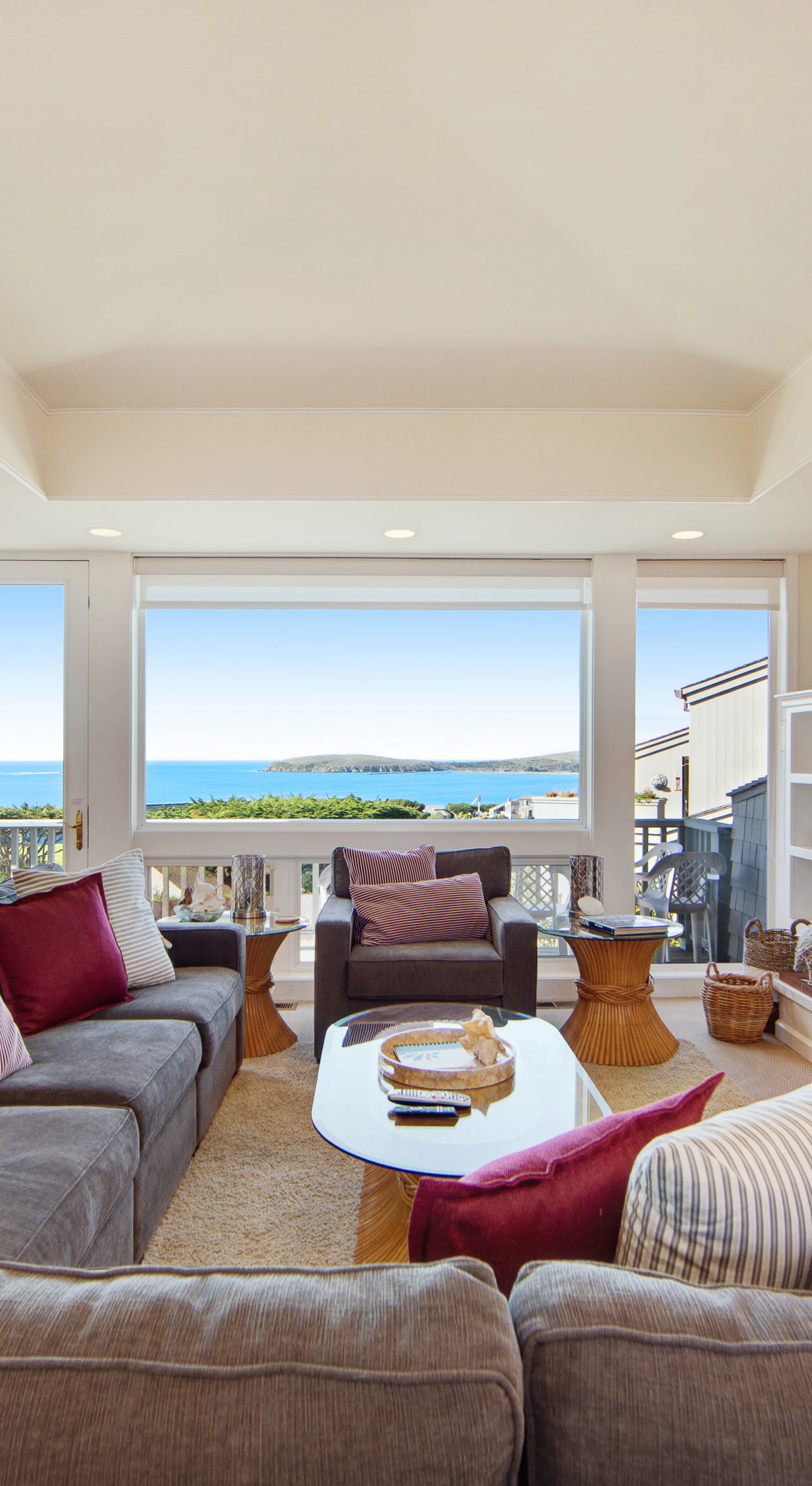 Panoramic ocean views flood the living room through floor-to-ceiling windows, creating your coastal living dream.