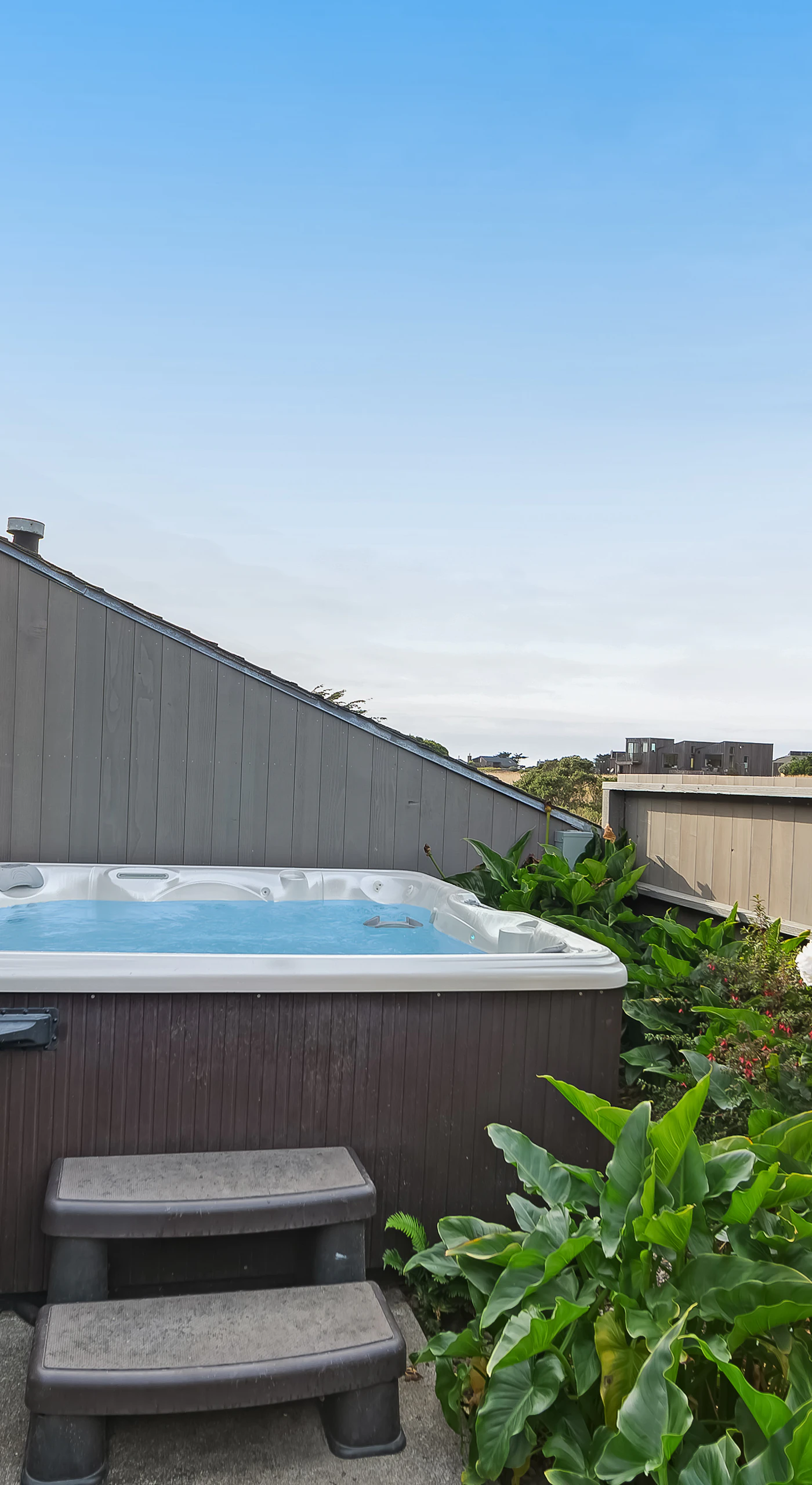 After a day of exploration, unwind in your private hot tub, surrounded by lush greenery and ocean breezes.