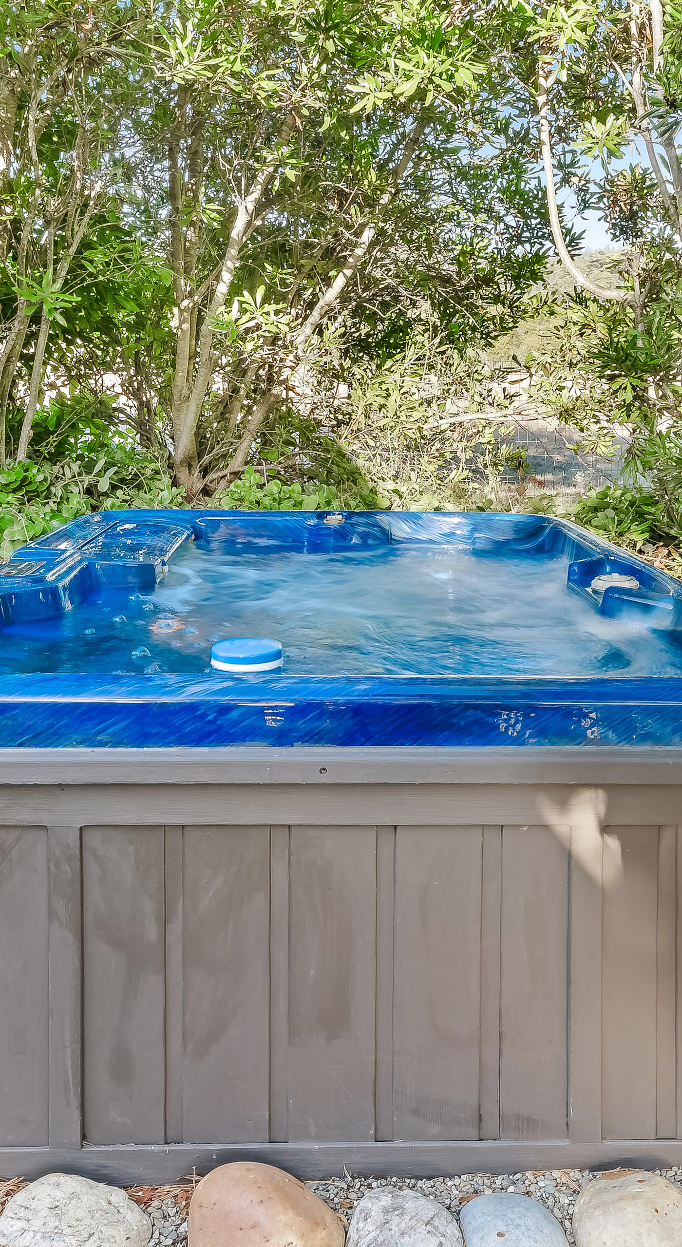 Indulge in soothing soaks in your private hot tub, nestled among lush greenery for a serene escape after a day of exploration.