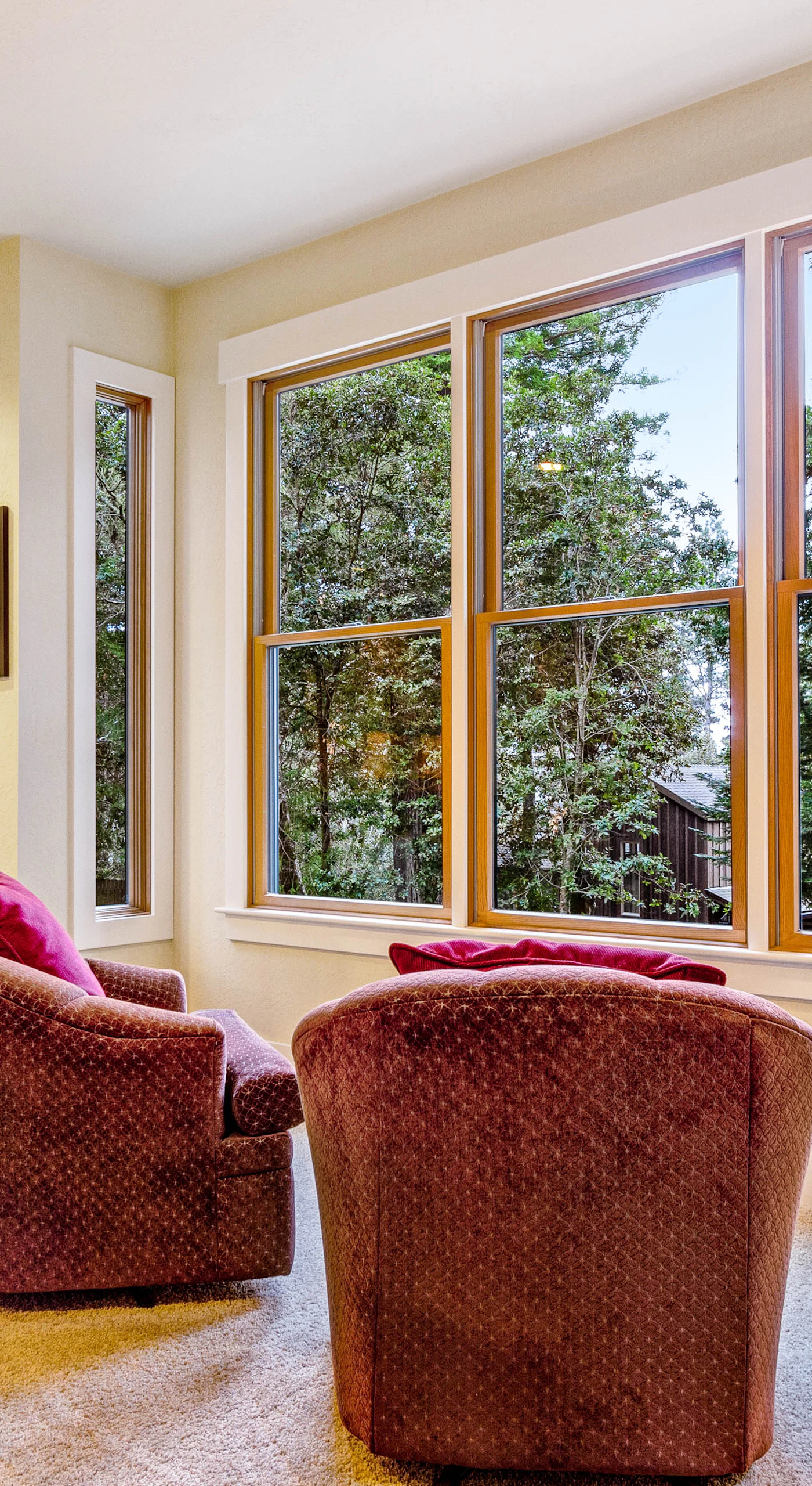Sip your morning coffee in the sunlit corner of the living room, surrounded by views of lush trees.