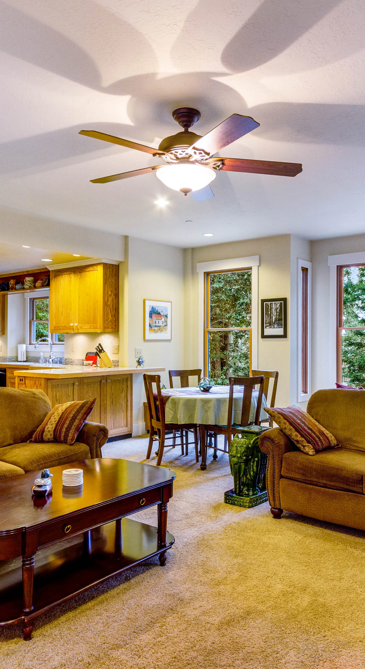 Picture yourself relaxing in the cozy living room, where large windows frame the vibrant greenery outside.