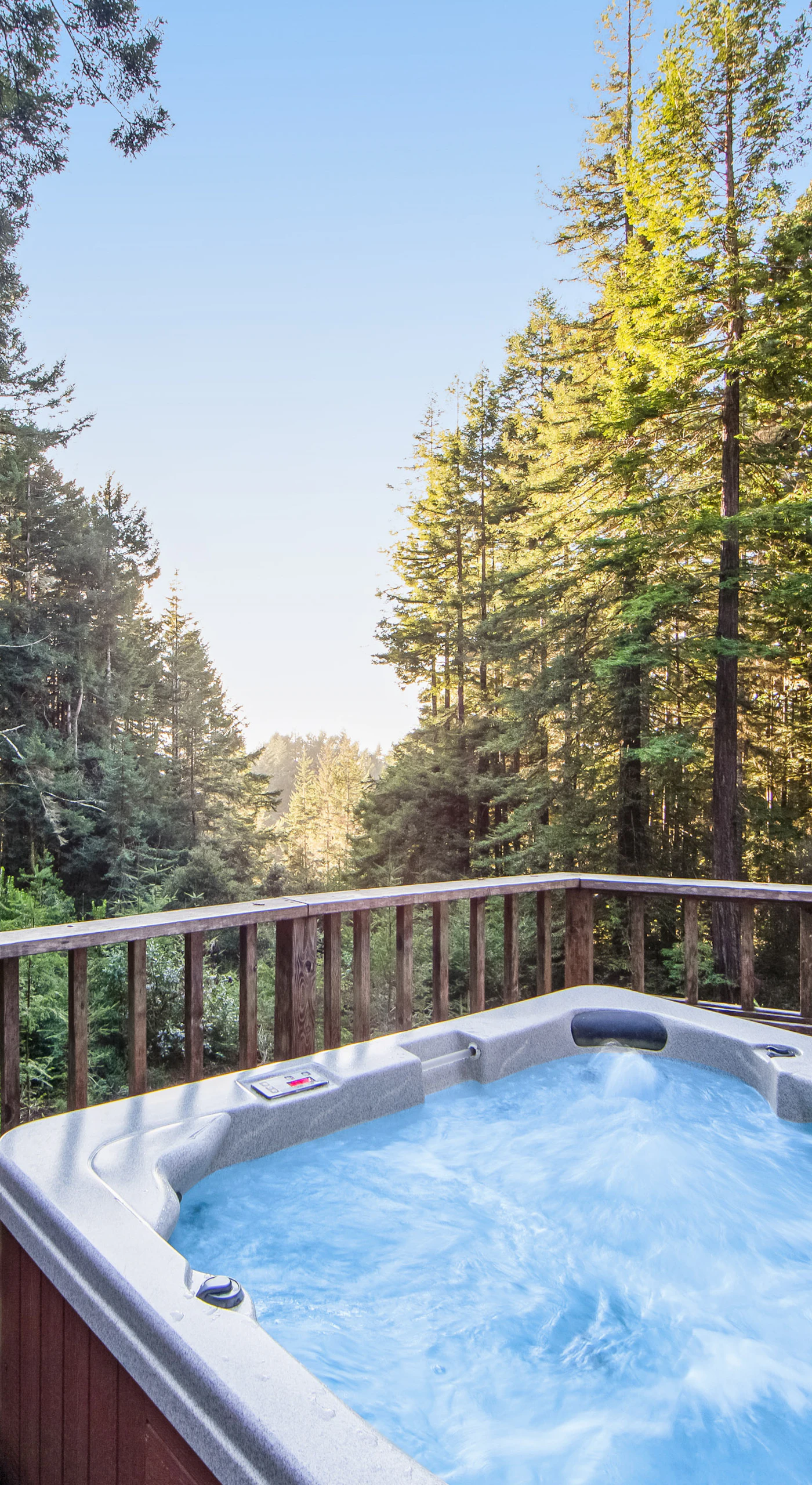 Soak in your private hot tub surrounded by towering trees, where tranquility meets nature and every sunset becomes a serene escape.