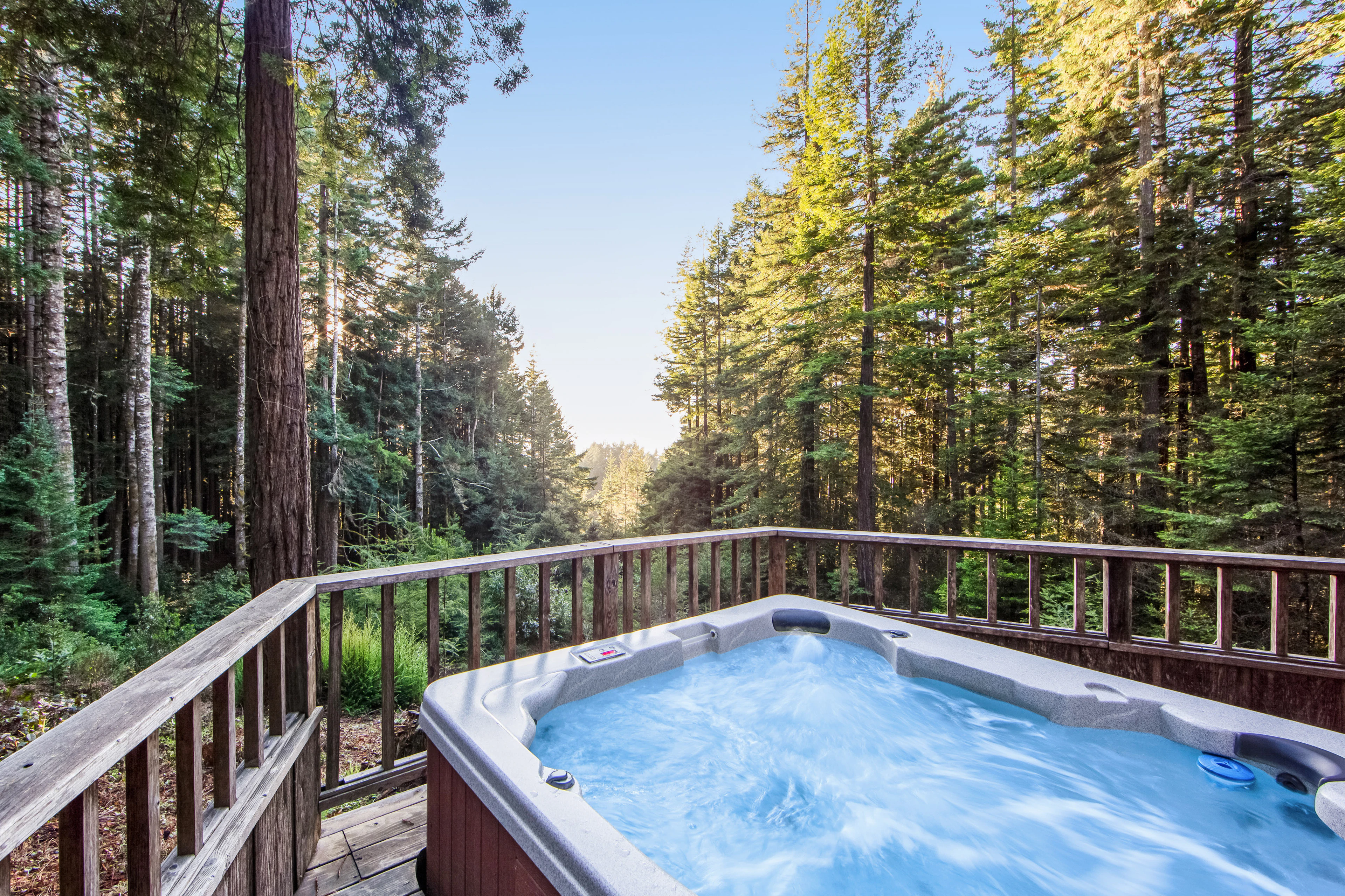 Soak in your private hot tub surrounded by towering trees, where tranquility meets nature and every sunset becomes a serene escape.