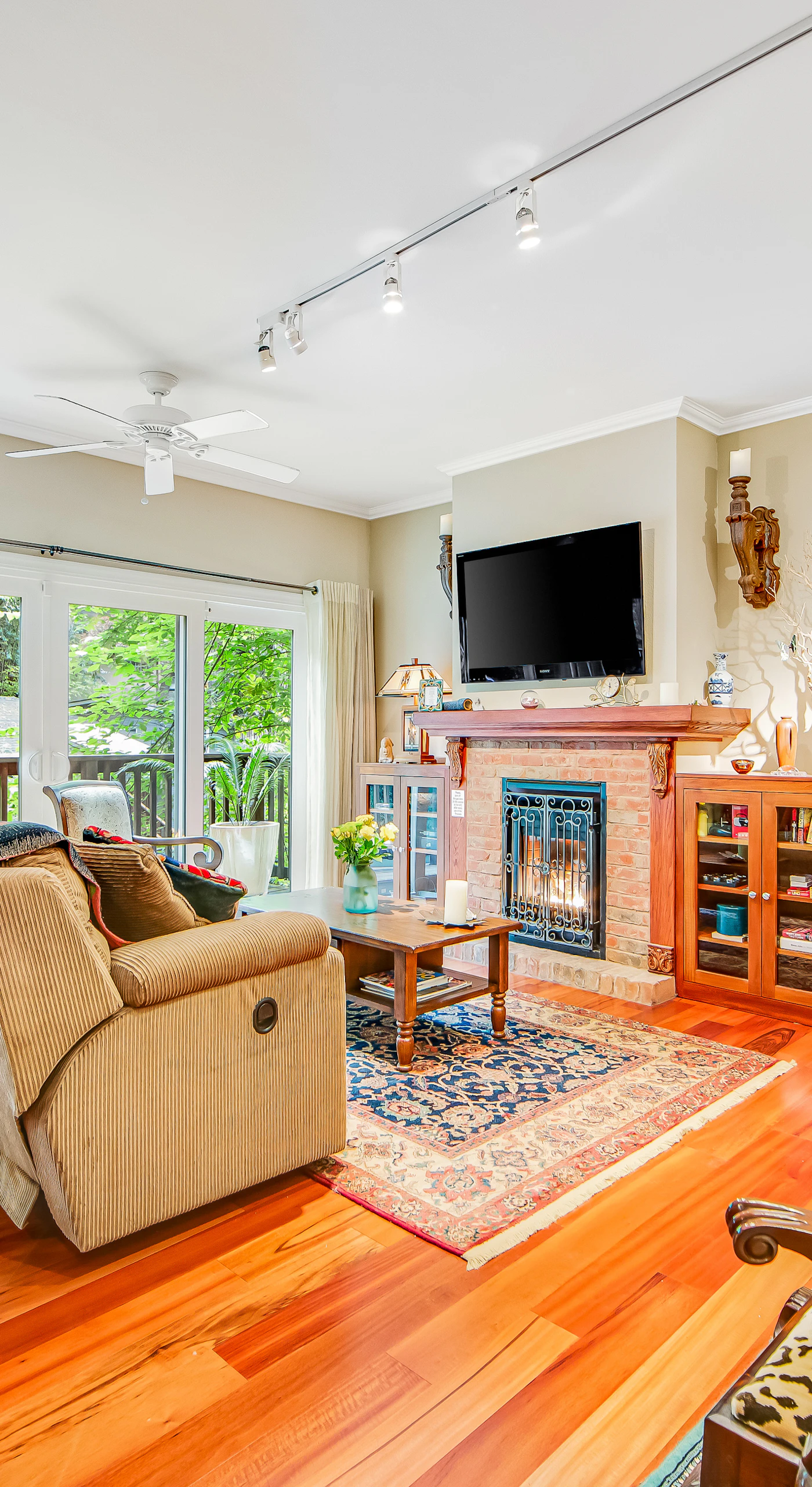Settle into your sun-drenched living room with gleaming hardwood floors, a cozy brick fireplace, and floor-to-ceiling windows framing the redwood canopy outside your door.