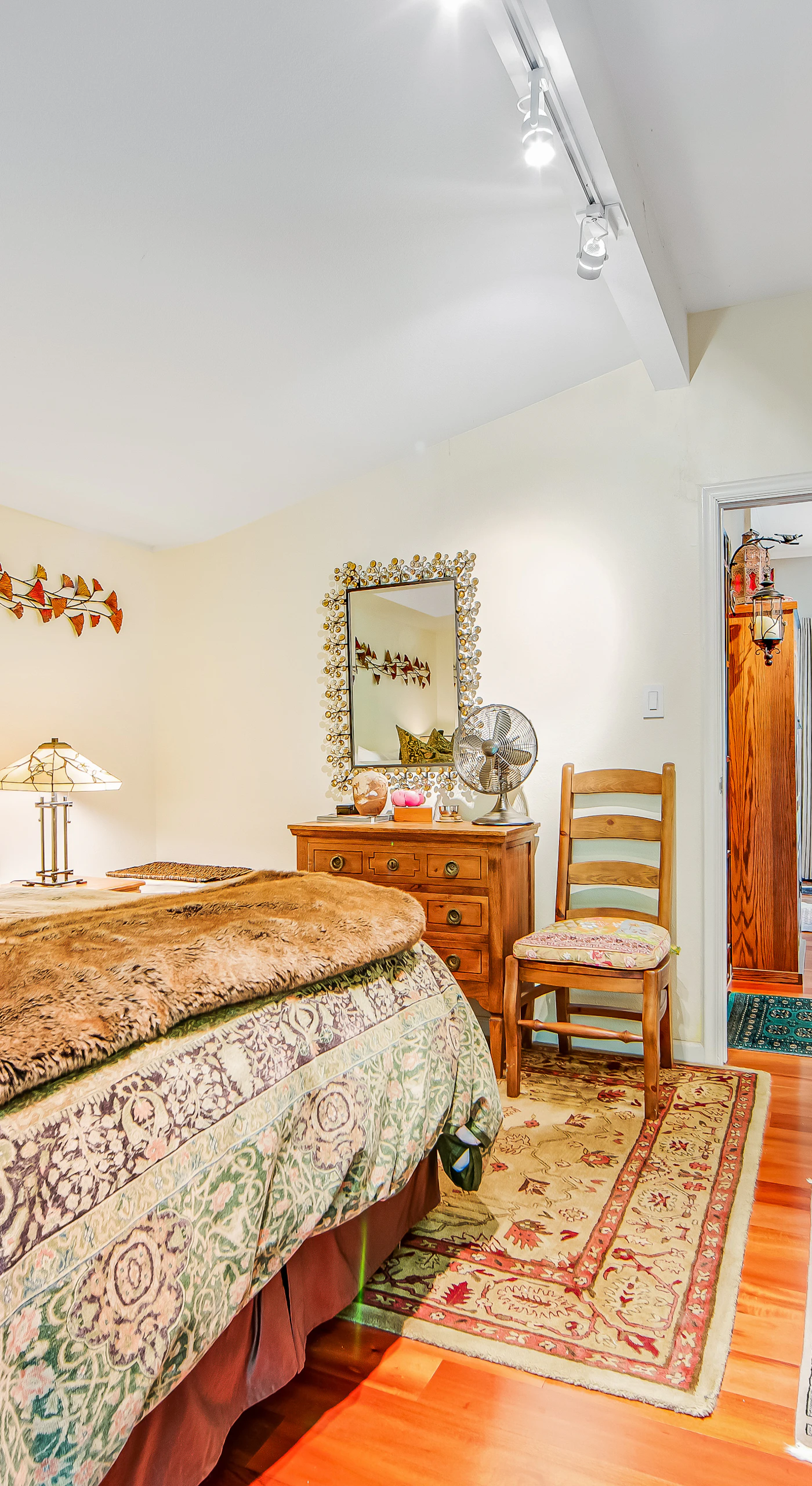 Retreat to your primary suite where vintage-inspired furnishings, a vanity mirror, and soft lighting create a restful sanctuary after a day of wine country tasting.