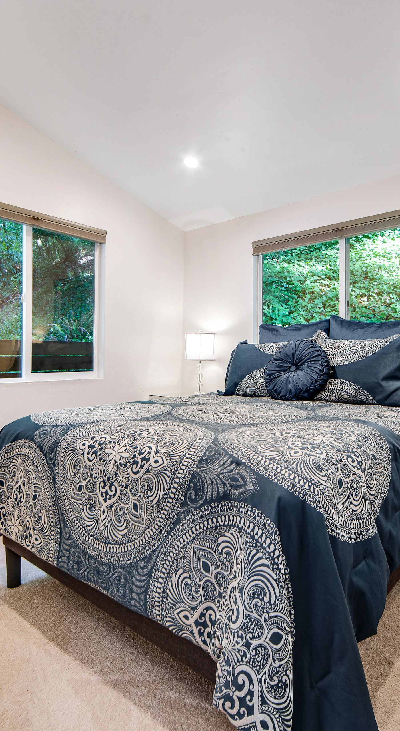 Drift off in your tranquil main-floor bedroom — a plush queen bed draped in designer linens with windows that frame nothing but lush redwood greenery.