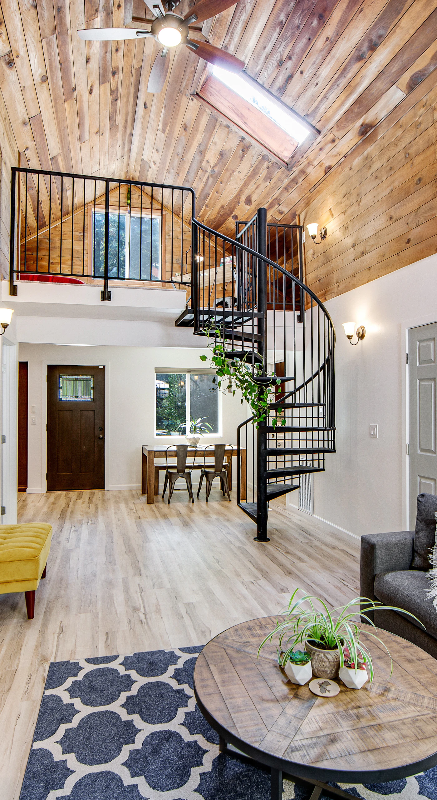 Take in the dramatic double-height living space — a striking spiral staircase leads to your private loft retreat above the redwood treetops.