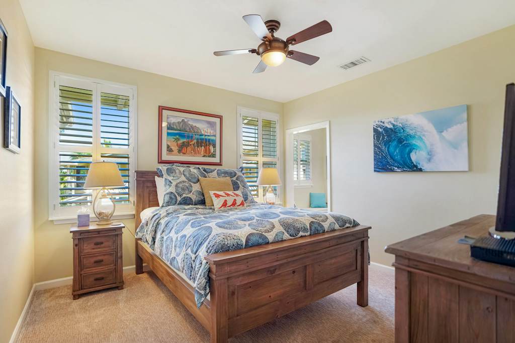Cozy queen bedroom with ceiling fan and natural light