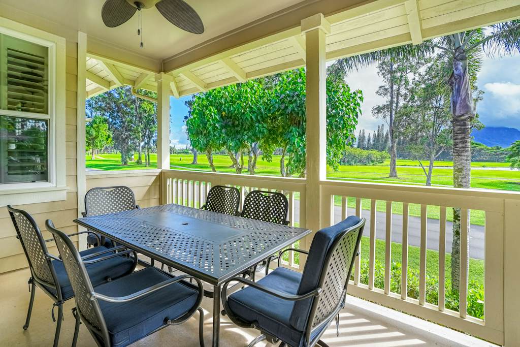 Covered porch with outdoor dining, surrounded by greenery