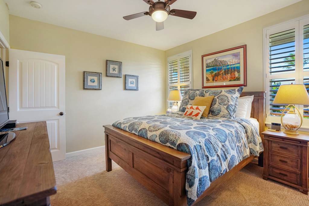 Queen bedroom featuring tropical décor and a comfortable bed