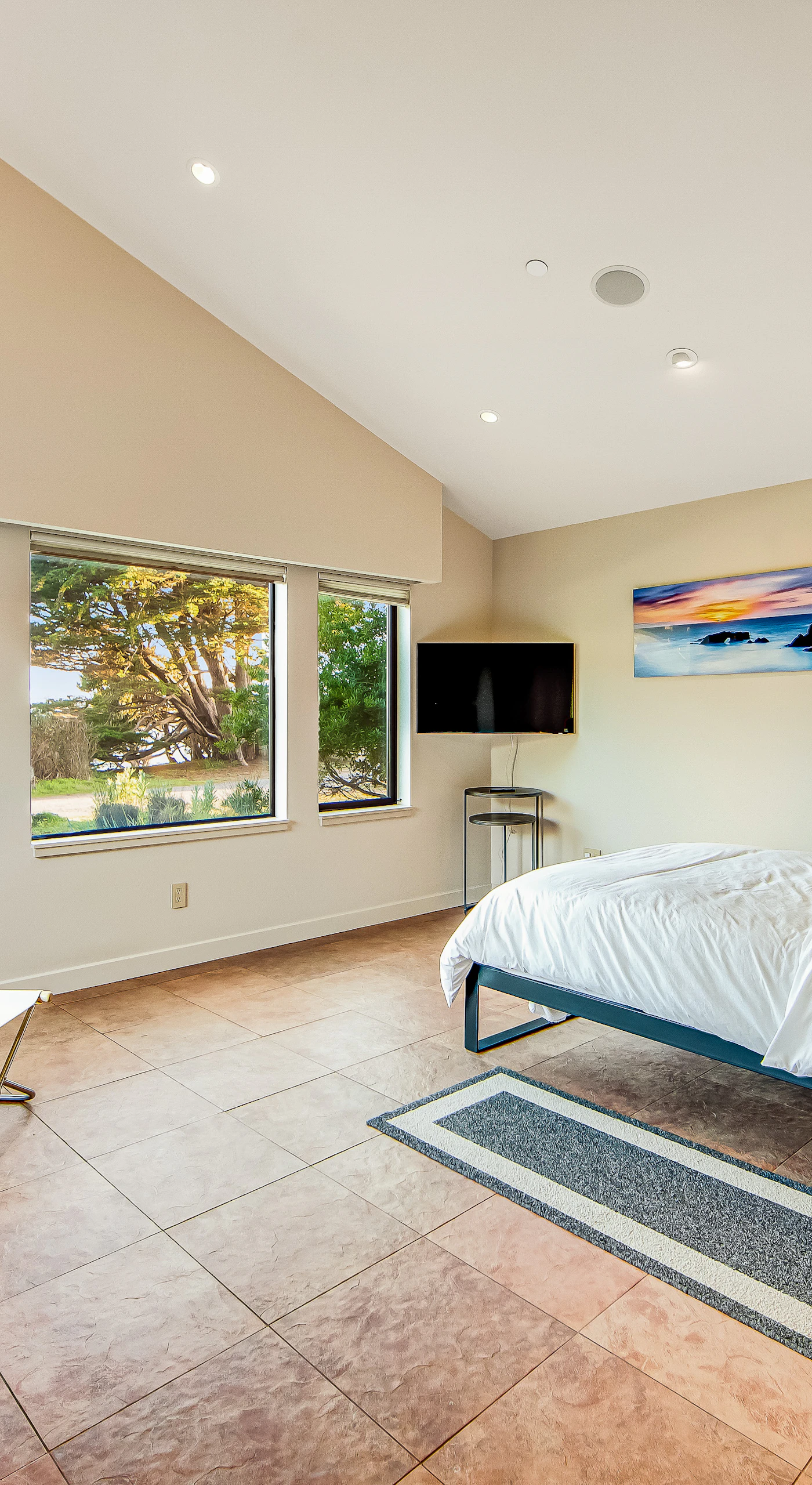 This spacious master suite offers a cozy reading nook, perfect for unwinding with a book while taking in the tranquil garden views.