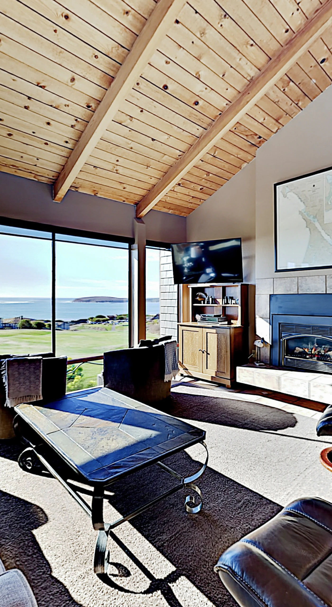 Sink into leather seating beneath your vaulted wood ceiling while the gas fireplace glows and panoramic views of the golf course and Pacific stretch before you.