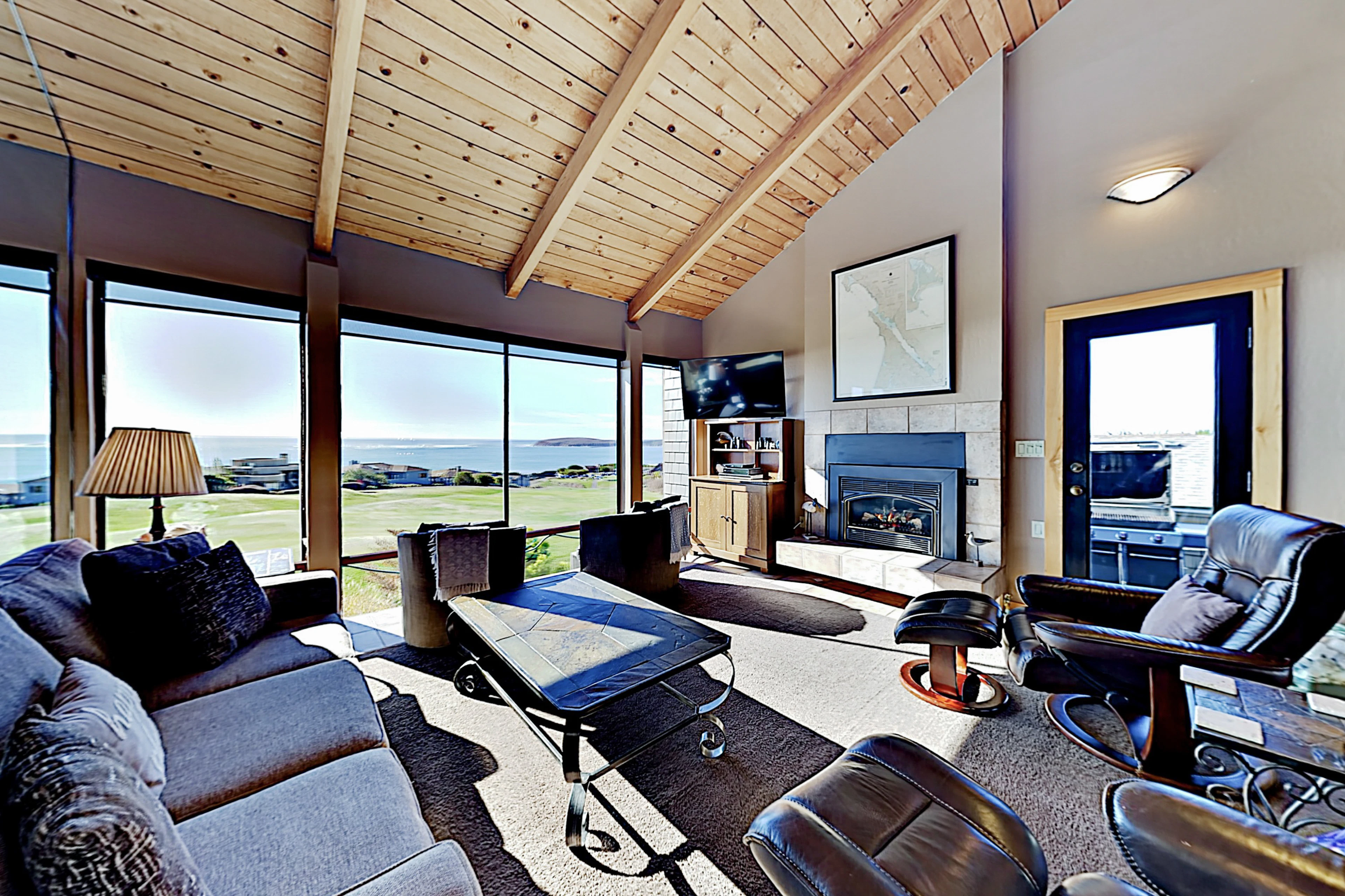 Sink into leather seating beneath your vaulted wood ceiling while the gas fireplace glows and panoramic views of the golf course and Pacific stretch before you.