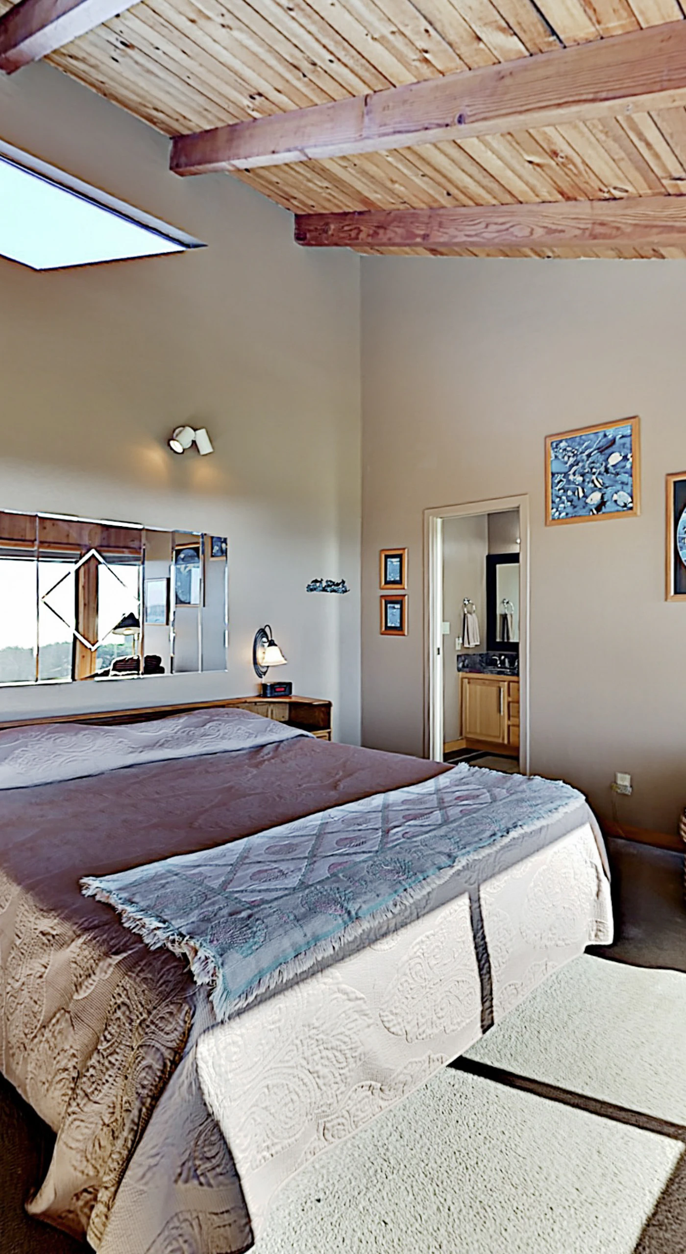Wake to golf course panoramas and peeks of Pacific blue in this master suite — vaulted wood ceilings, a skylight, and a reading nook make mornings unforgettable.