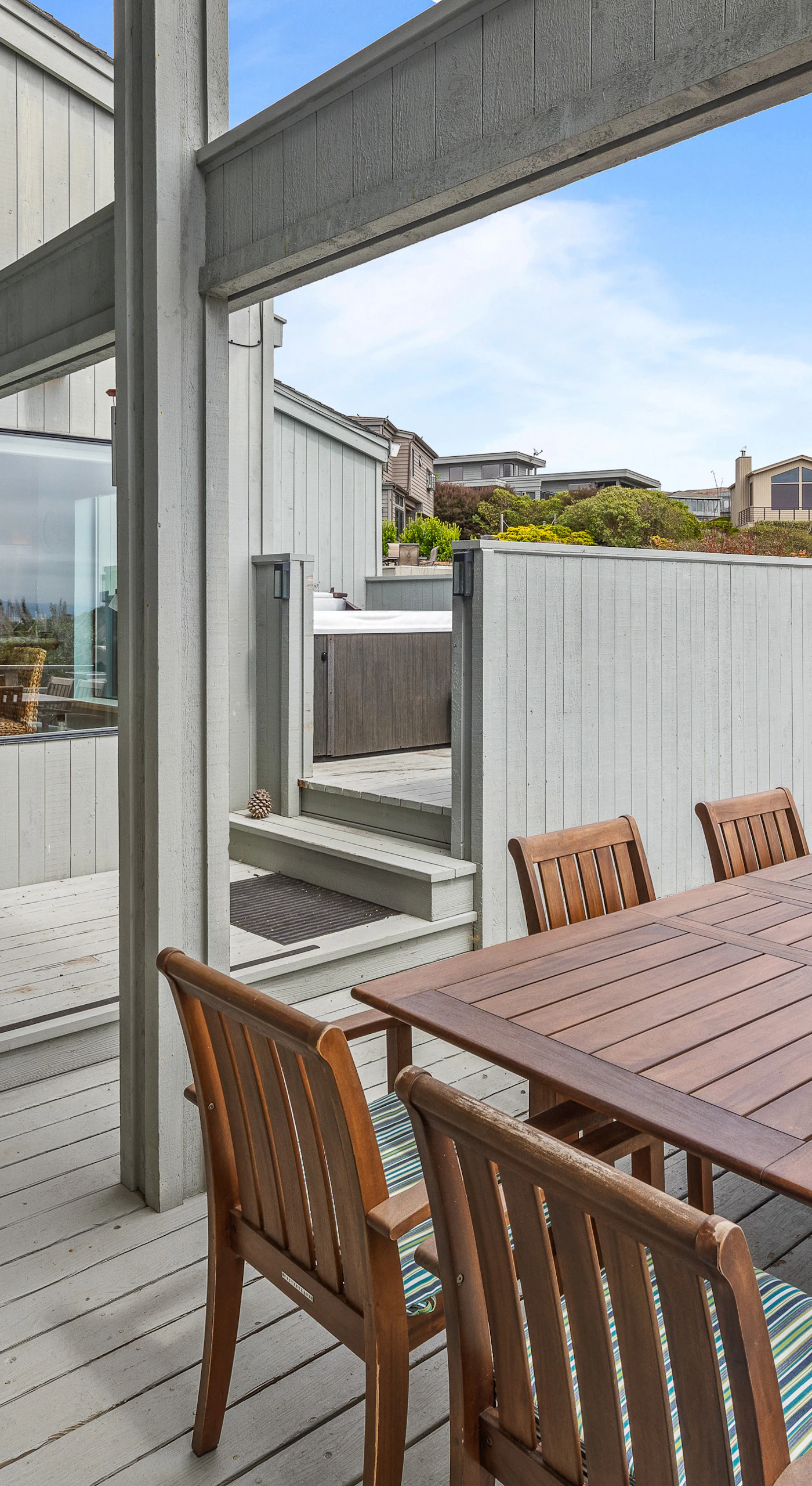 Dine outdoors on the sheltered lower deck, steps from the kitchen and surrounded by flowering coastal shrubs.