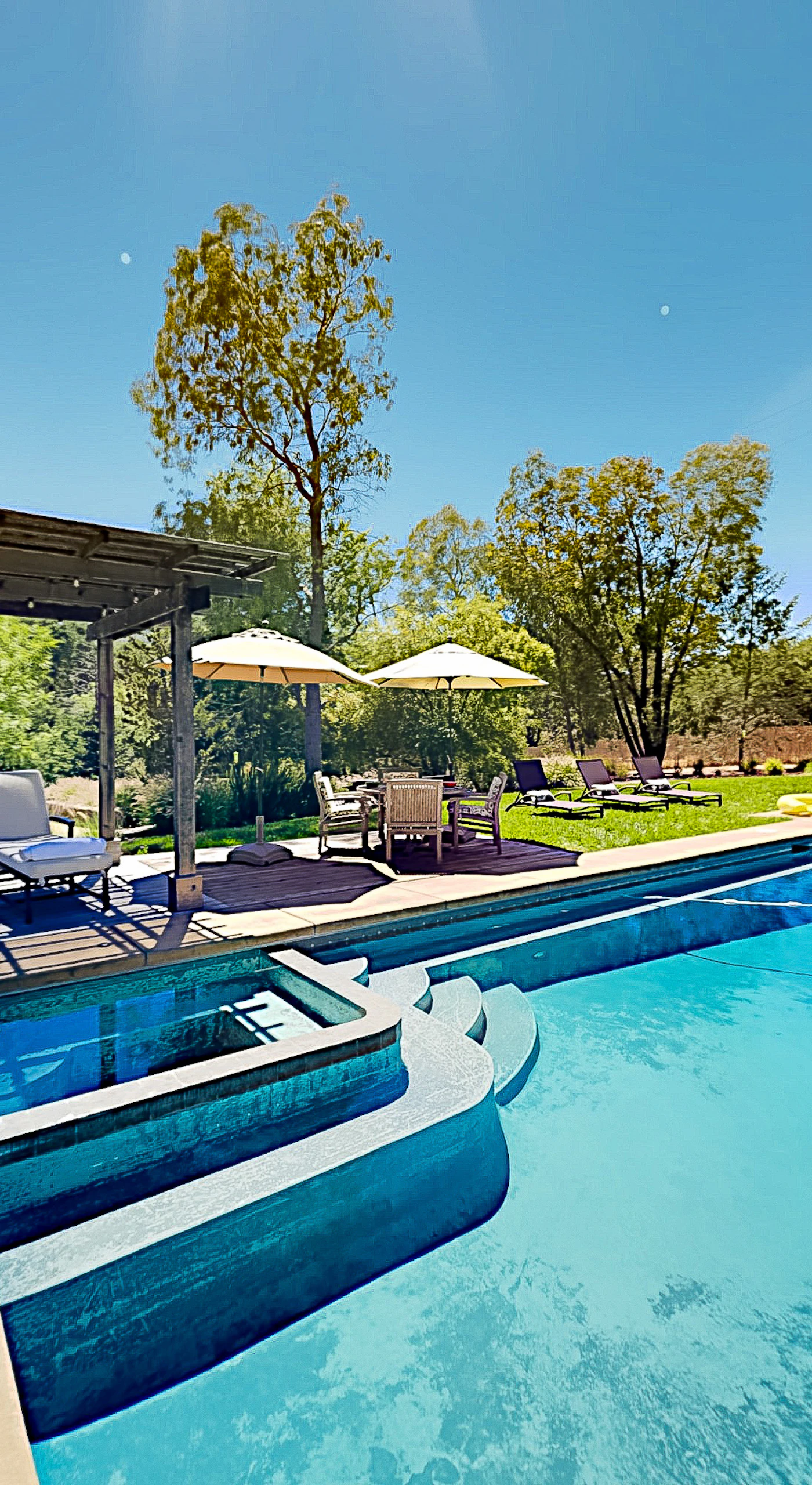 Dive into your private Glen Ellen oasis — a sparkling heated pool and built-in hot tub await beneath the pergola, with sun loungers ready for your wine country afternoon.