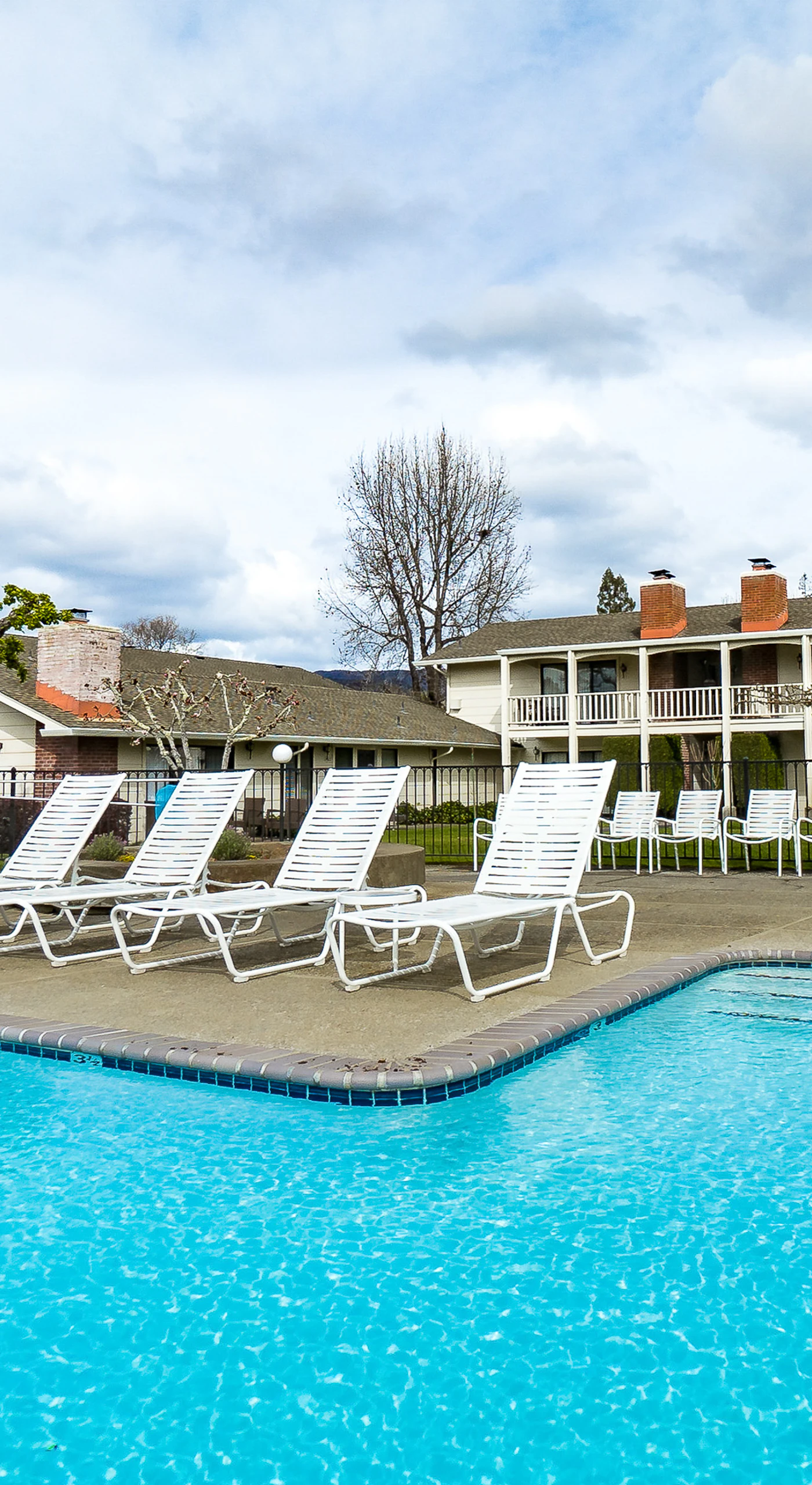 Lounge poolside under Napa Valley sunshine at your resort pool — chaise lounges and shaded seating await after a day of wine tasting