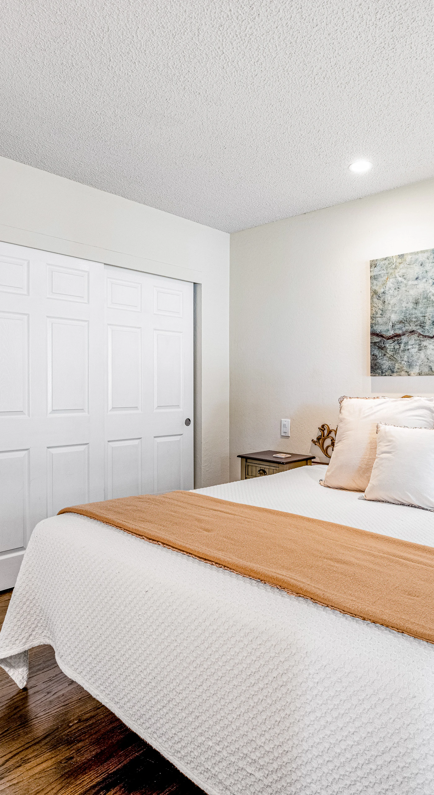 Retreat to your serene queen bedroom — warm gold accents, art-filled walls, and a generous closet give you a true home base in the heart of wine country.