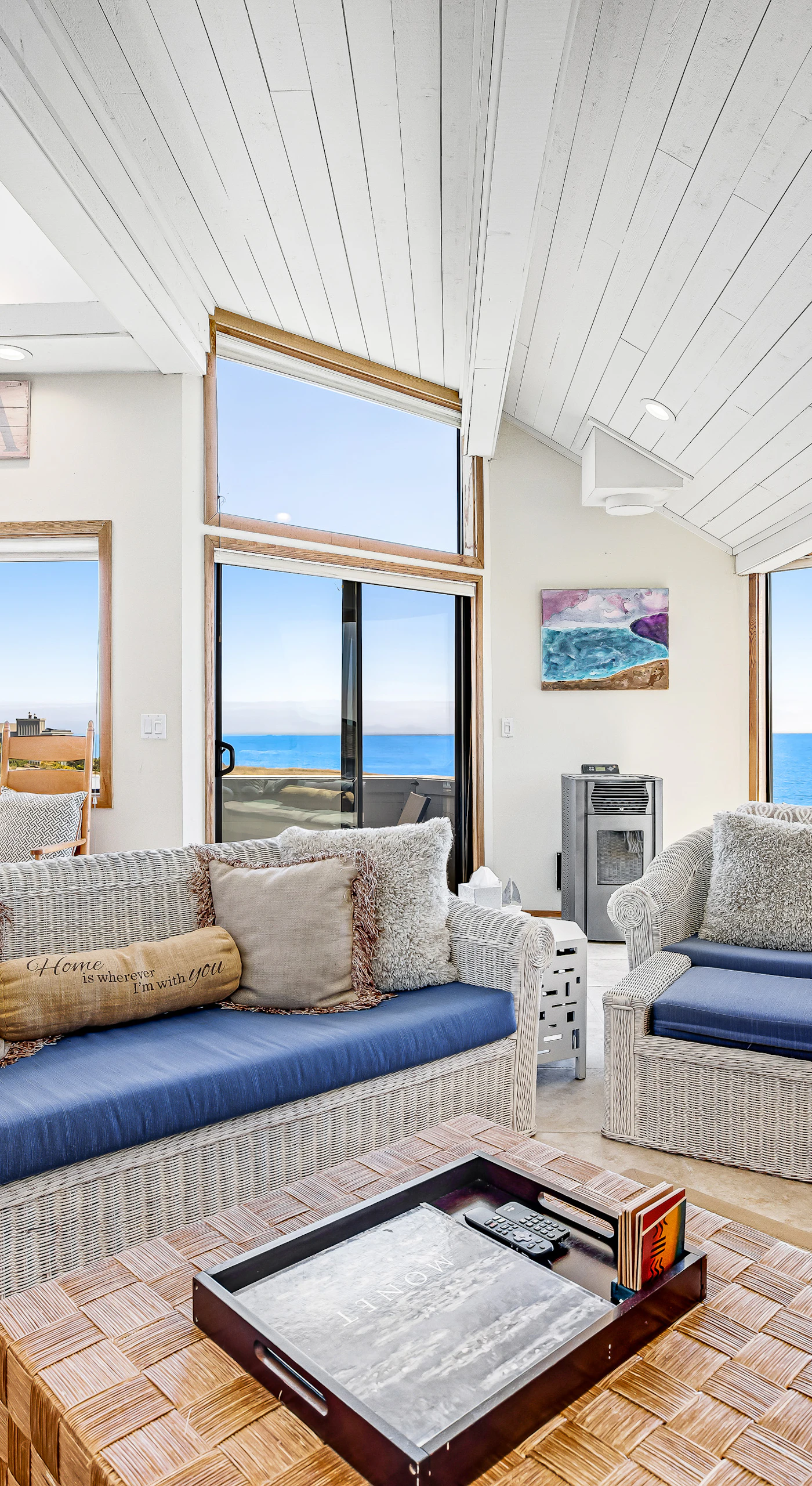 Sink into coastal comfort in your sun-drenched living room where panoramic Bodega Bay views stretch across the horizon through floor-to-ceiling windows