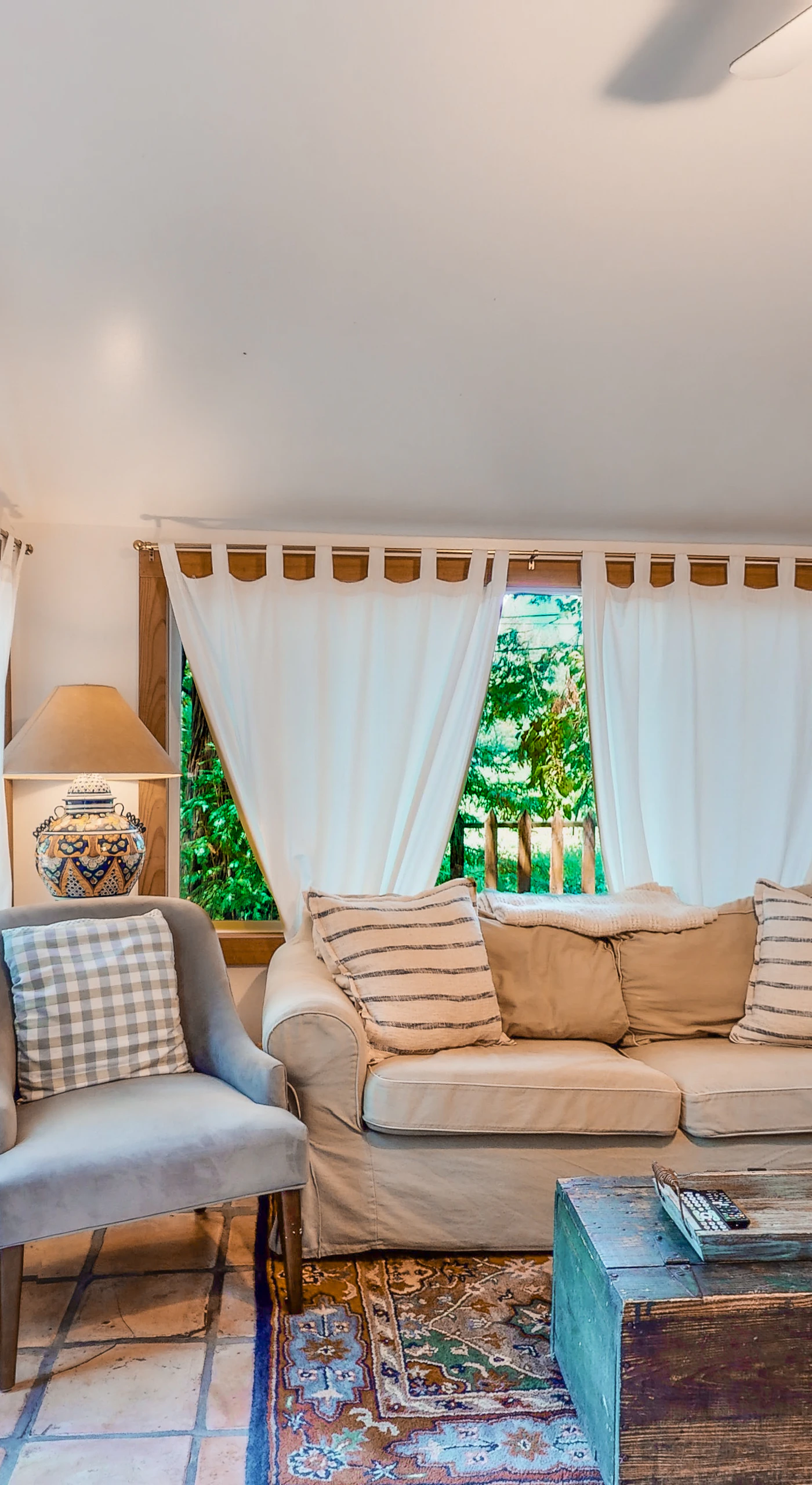 Spot a curious telescope by the window and settle into the cozy sitting area — your cottage living room blends charm with redwood-framed views.