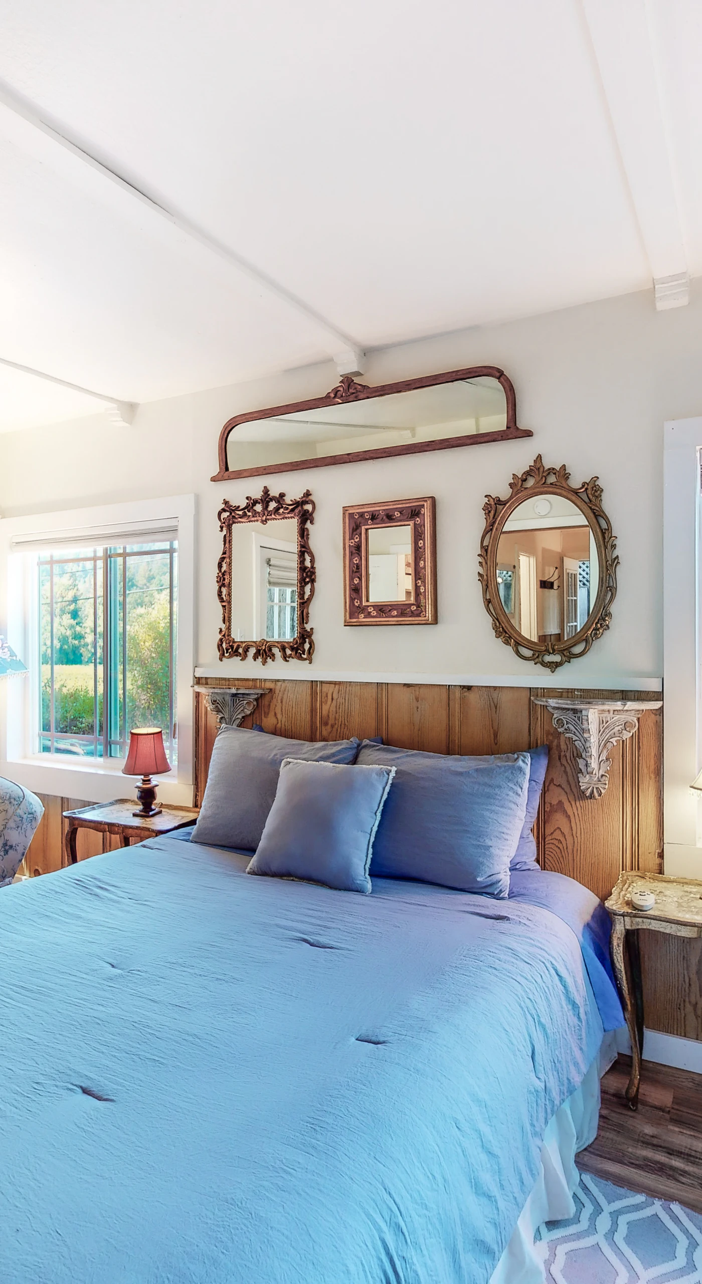 Wake to lush green views in your sunlit master suite — a queen bed, window-side daybed, and vineyard panoramas make this your wine country sanctuary.