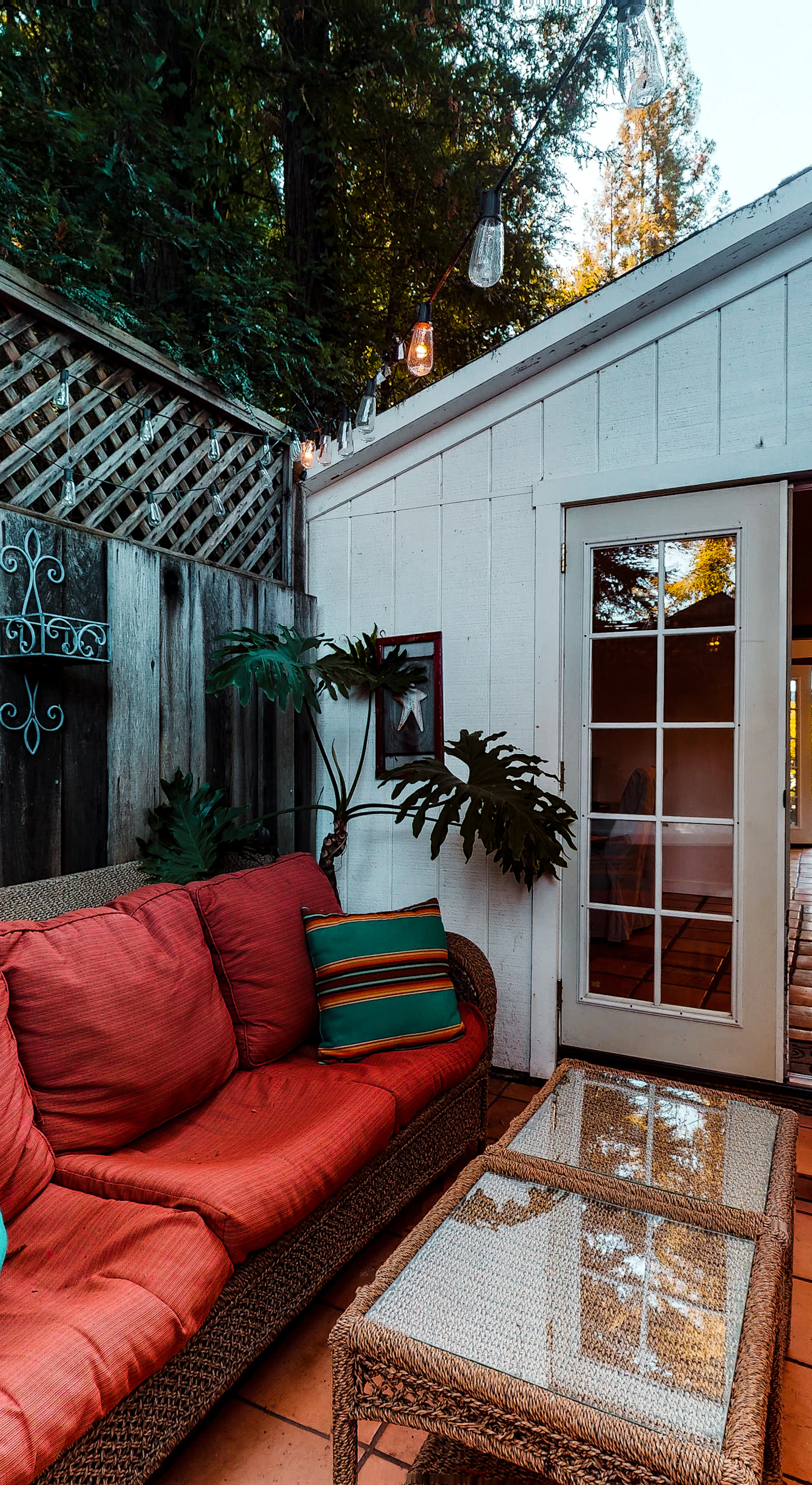 As twilight settles over Guerneville, your cottage glows warmly through open French doors — step between indoor comfort and your private patio retreat.
