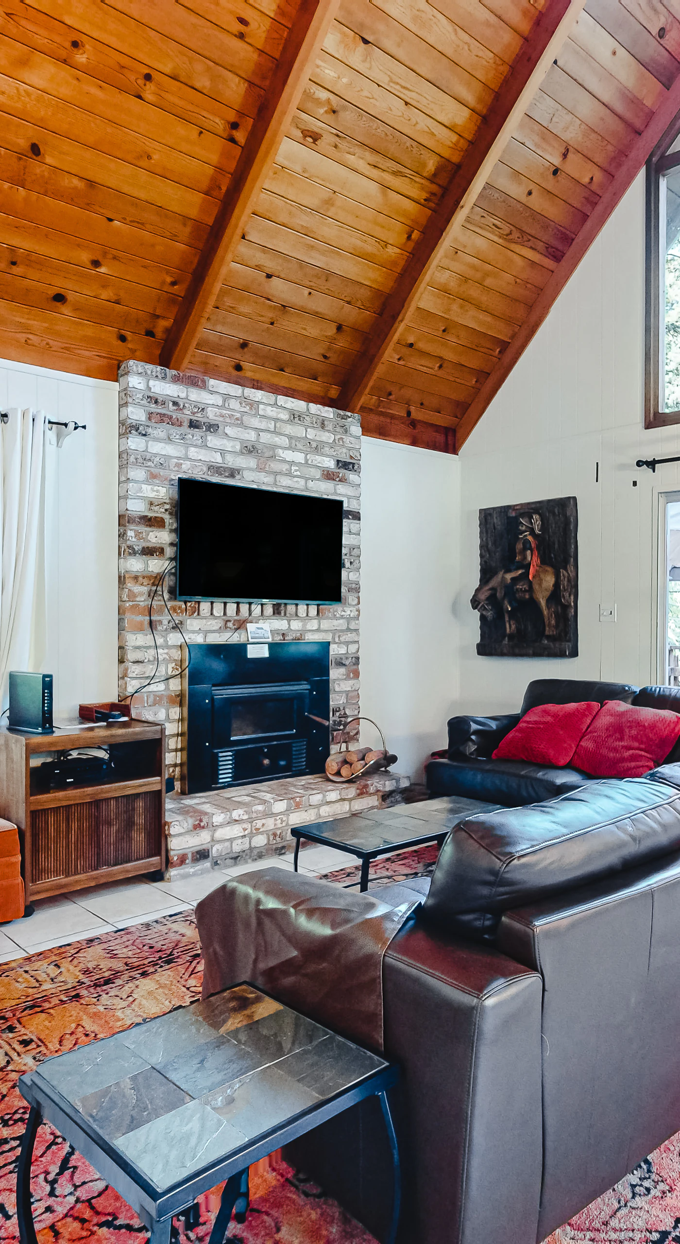 Gather around the wall-mounted TV after a day of wine tasting — your living room blends rustic redwood charm with cozy modern comforts.