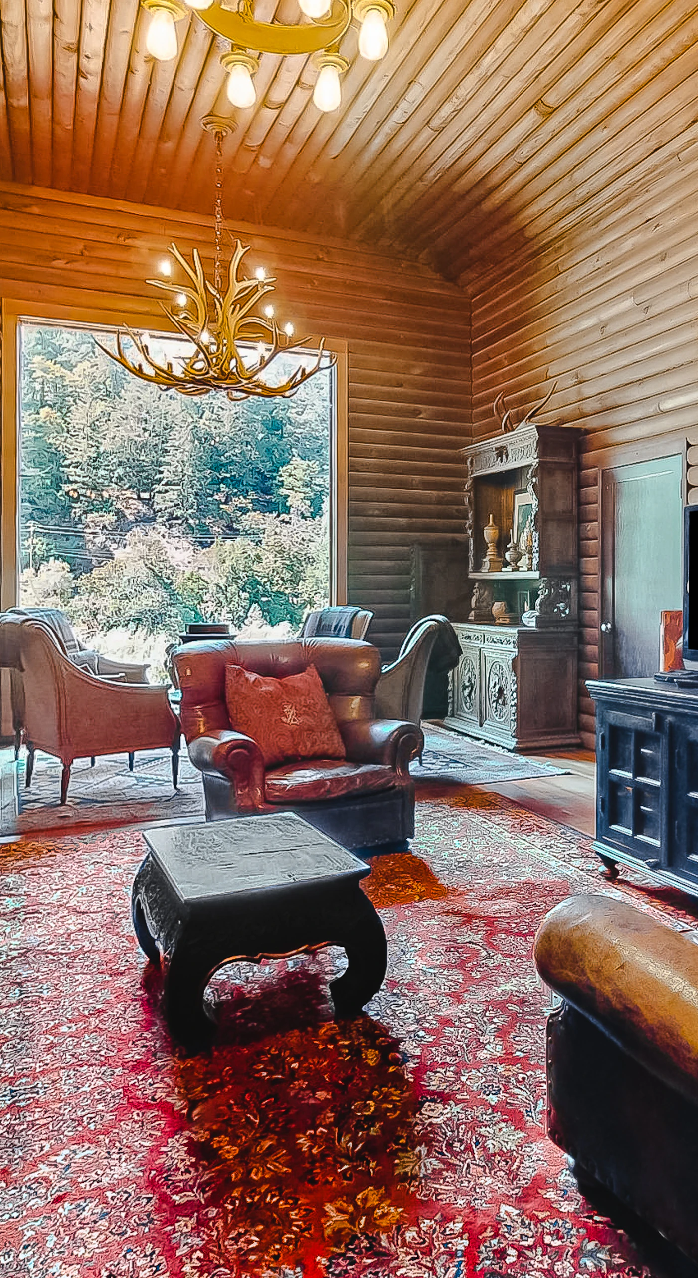 Gather your group around the flatscreen after a day of Sonoma wine tasting — plush seating, a loft staircase, and warm log walls wrap you in lodge comfort.