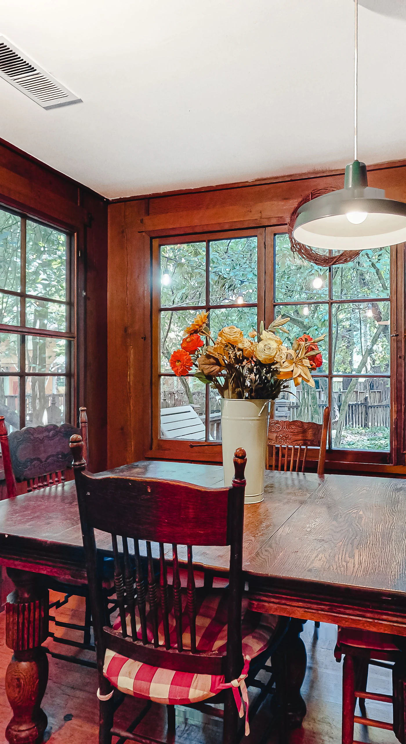 Morning light streams through floor-to-ceiling windows as you enjoy breakfast at your dining table — redwoods and deck just beyond the glass.