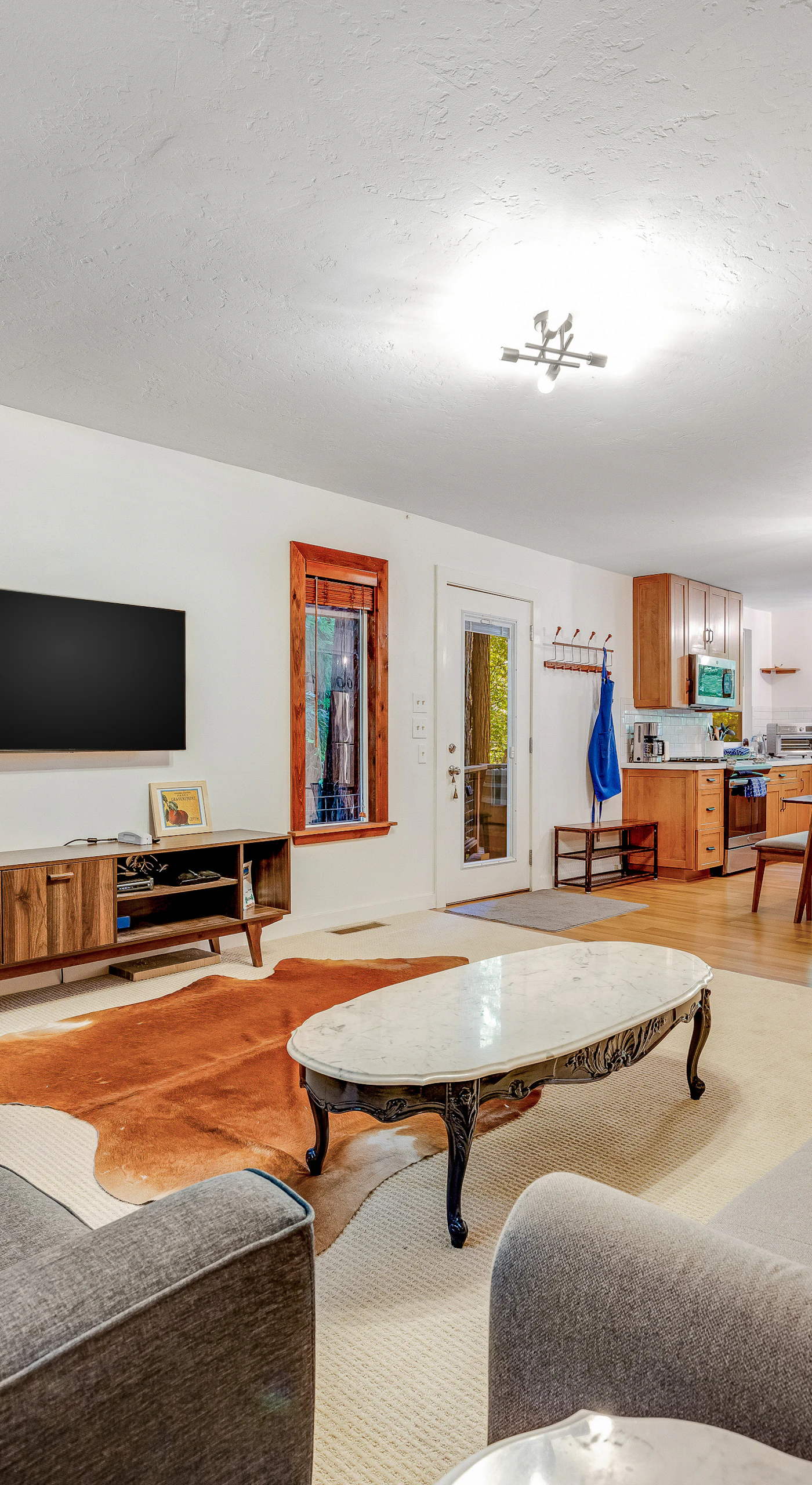 Stretch out in your open-concept living area with ample seating, a flat-screen TV, and a stylish cowhide rug — the kitchen is steps away for easy entertaining.