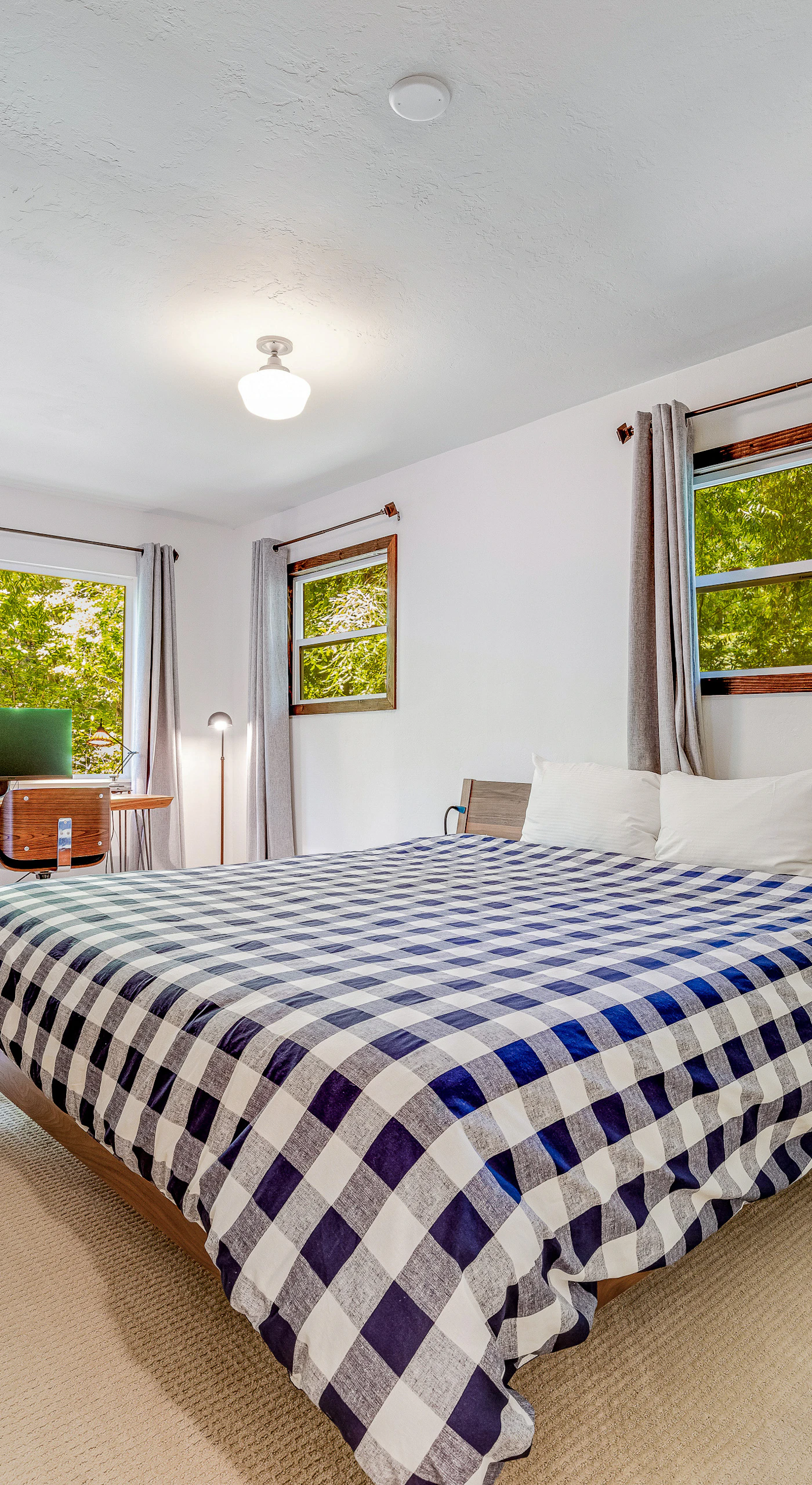Two walls of windows fill your primary bedroom with soft forest light — sink into a king bed and let the stillness of Cazadero lull you to sleep.