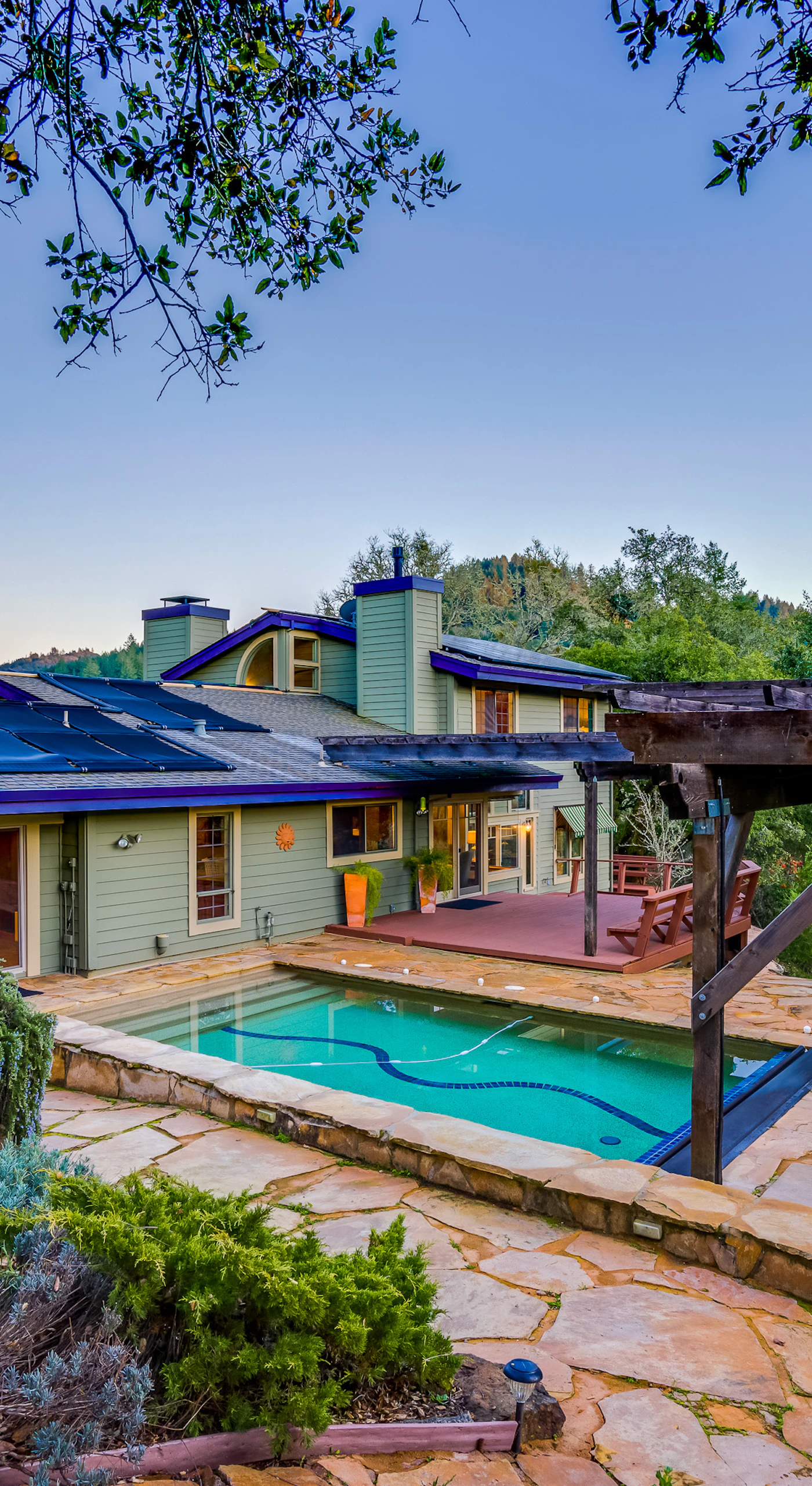 Your private hilltop retreat awaits — pool, pergola, and stone terrace framed by Sonoma County oaks under a golden sunset sky.