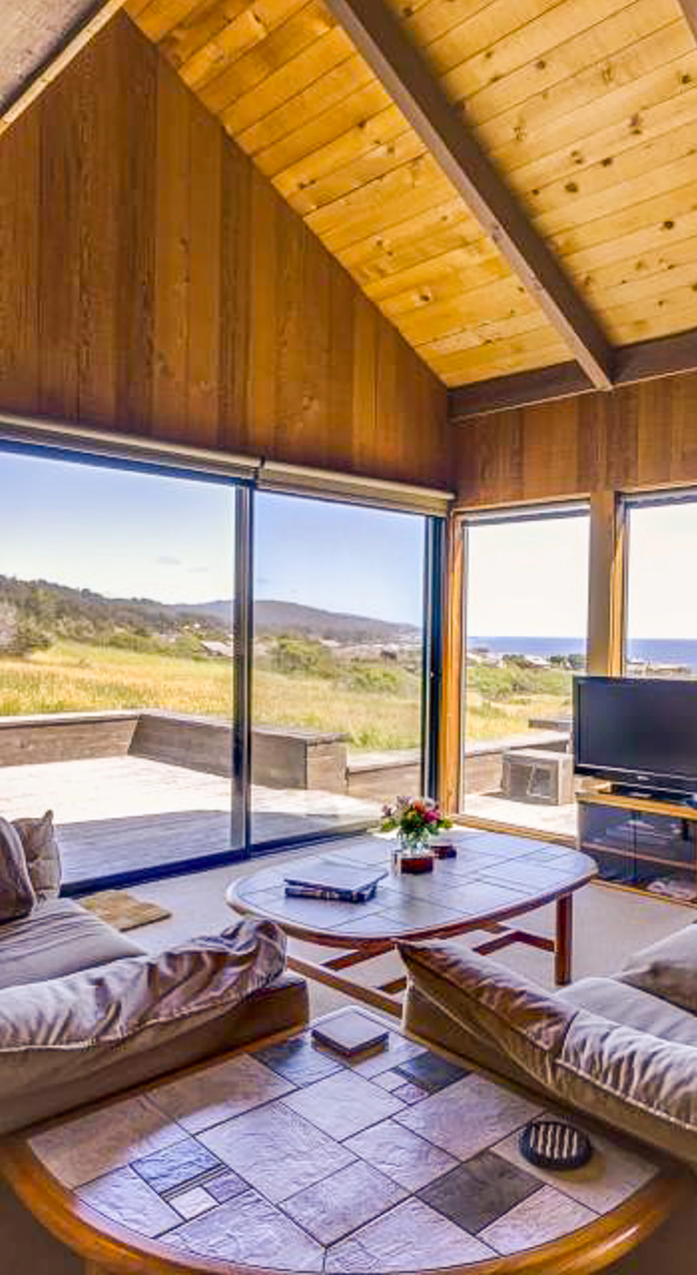 Gaze out at the rolling hills and ocean from this cozy living area, where comfort meets stunning views.
