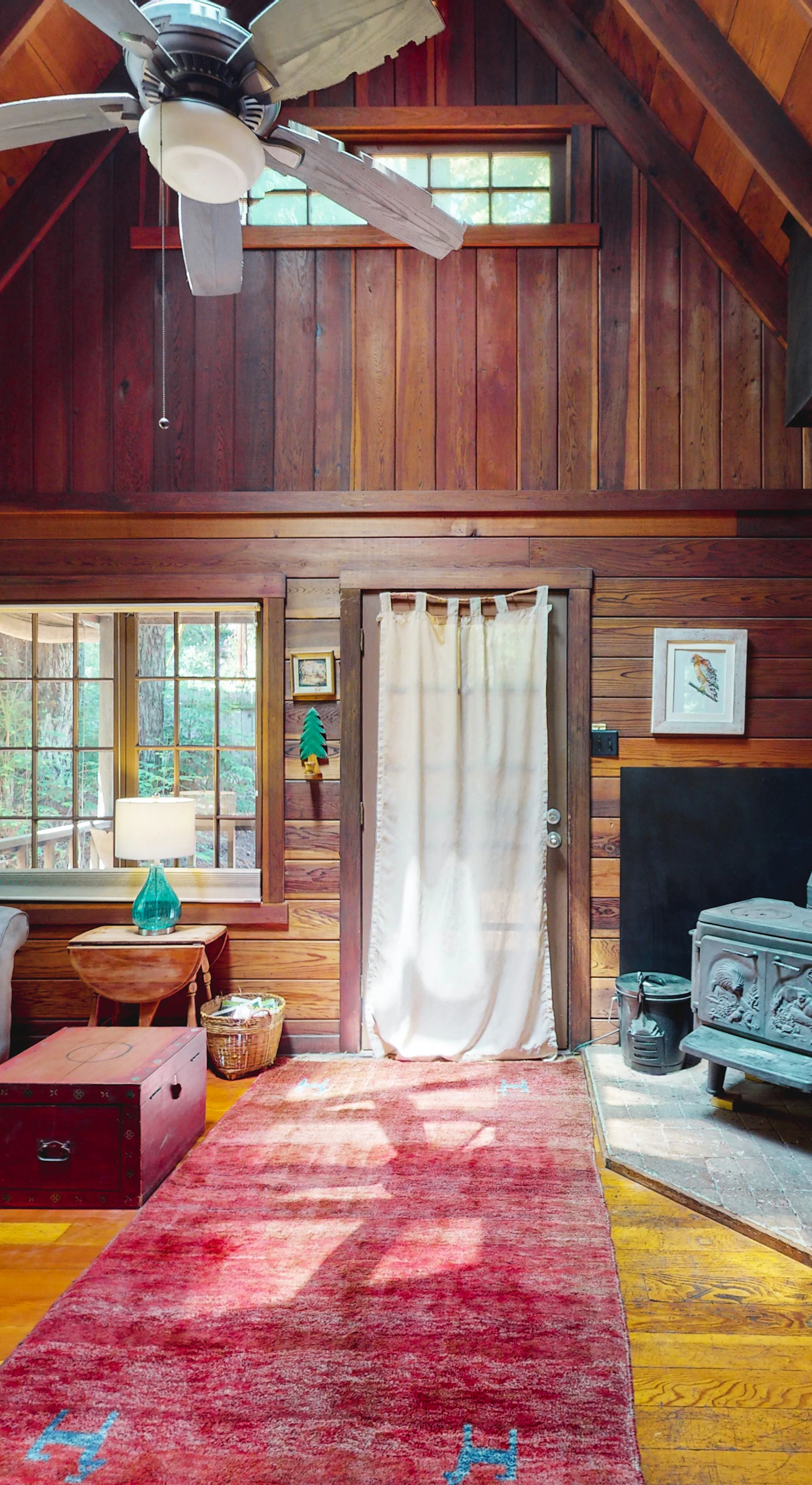 Unwind in your vaulted redwood living room where a cozy gas stove, plush sectional, and warm wood paneling wrap you in true Cazadero cabin comfort.