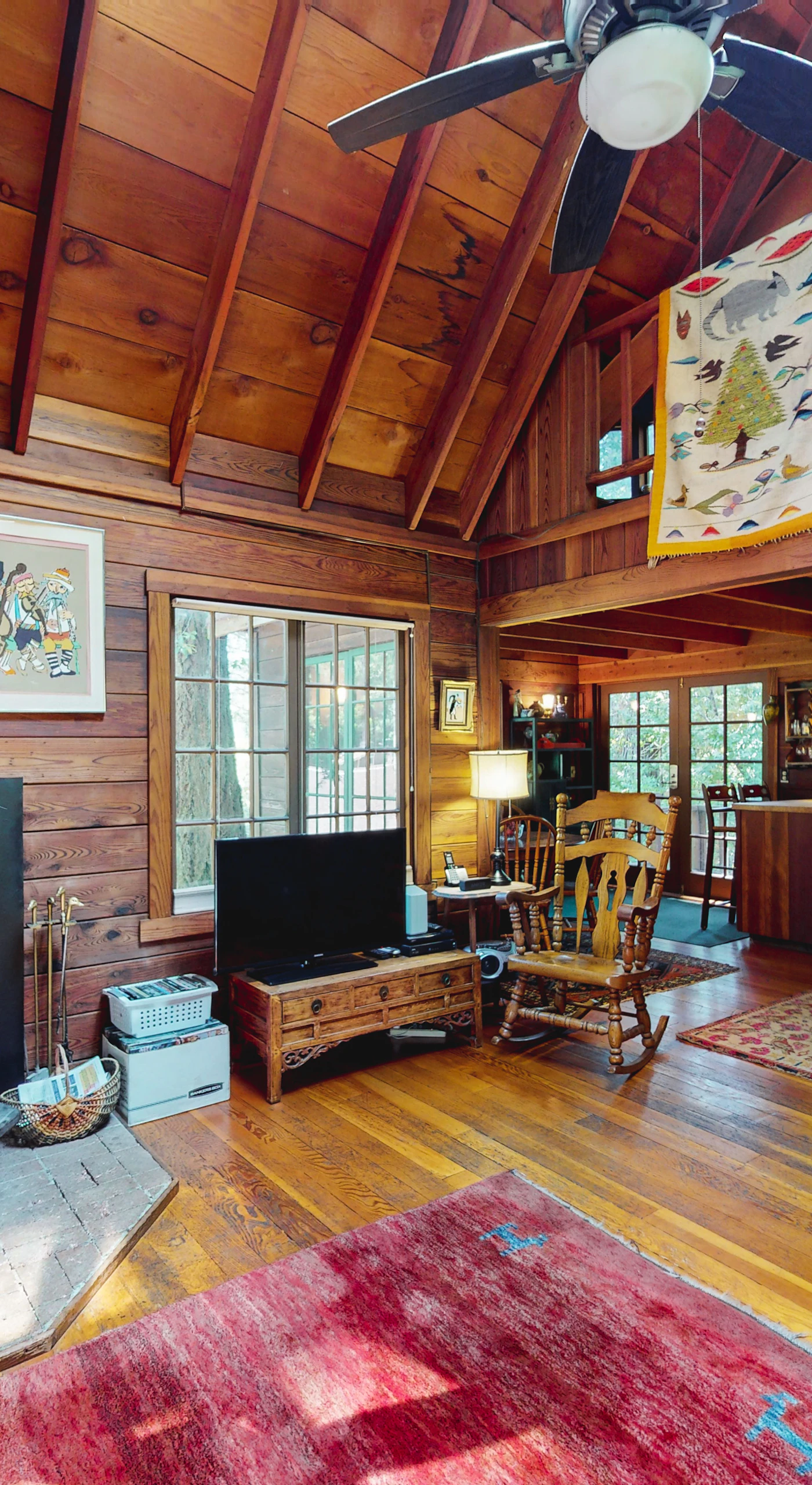 Gather around the stove in your soaring A-frame great room — vaulted redwood ceilings, eclectic art, and a peek at the loft above make every Cazadero evening memorable.