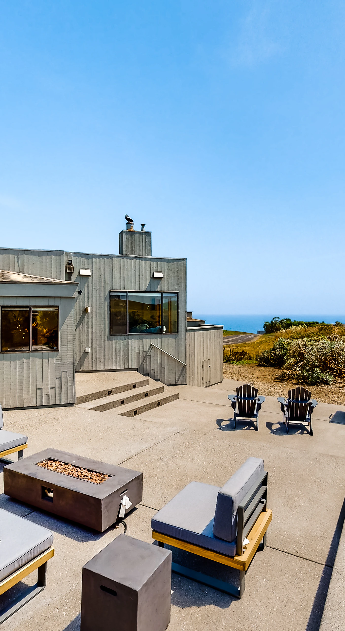 Unwind on your expansive private patio with plush lounge seating, Adirondack chairs, and a fire pit framed by sweeping Pacific Ocean views
