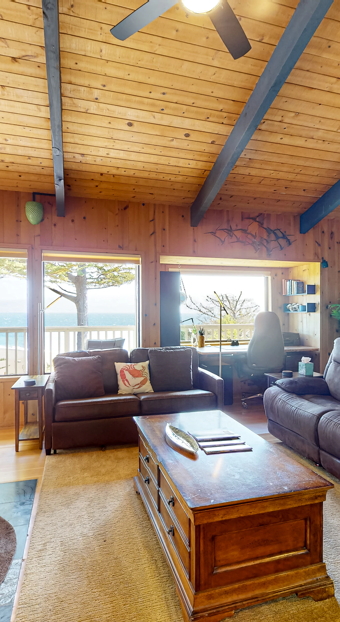 Relax by the fireplace in this comfortable living room, where every moment is elevated by the stunning coastal views.