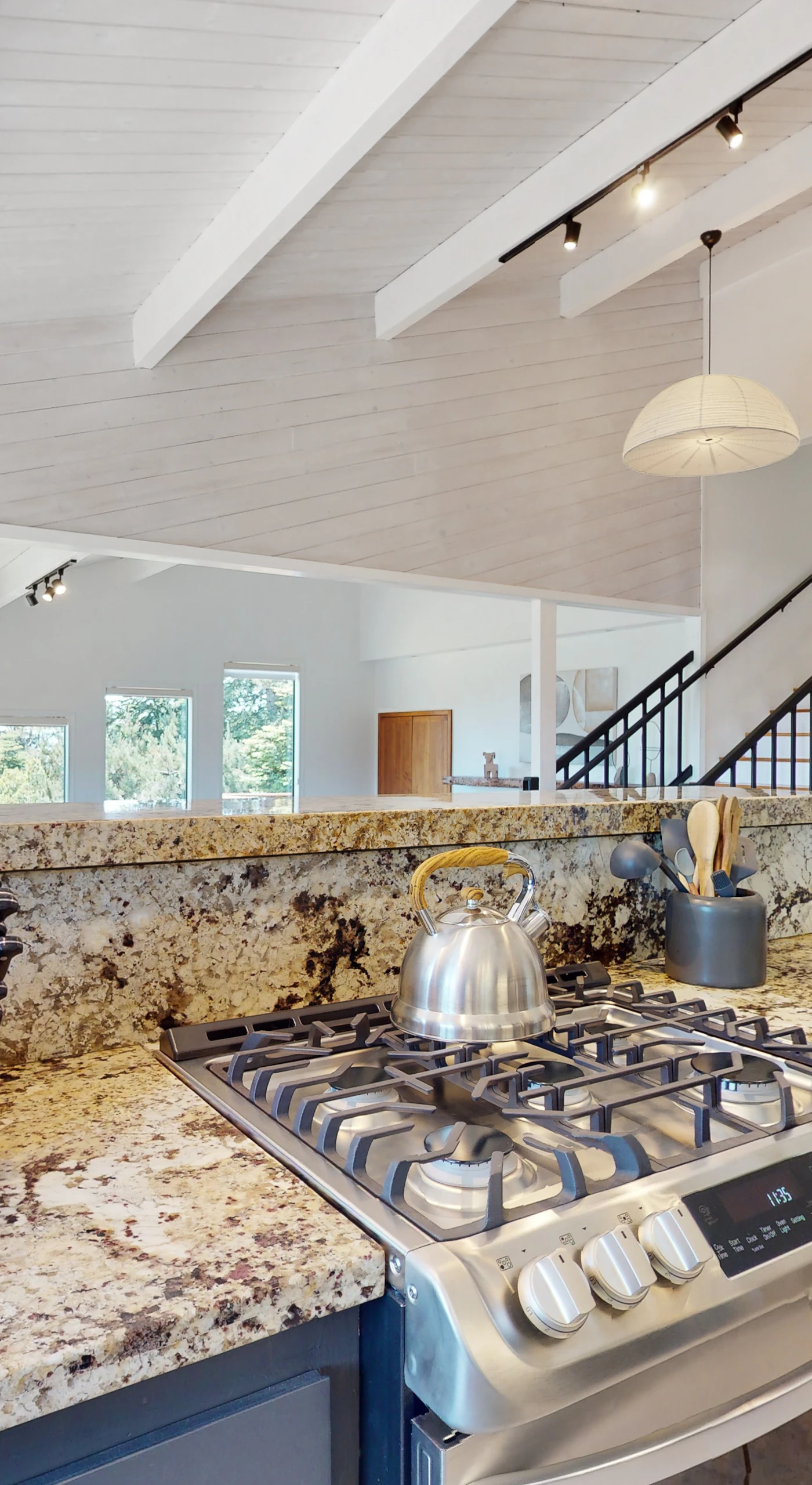 The kitchen's sleek design and gas range invite you to whip up delicious meals while enjoying the vibrant views just outside.