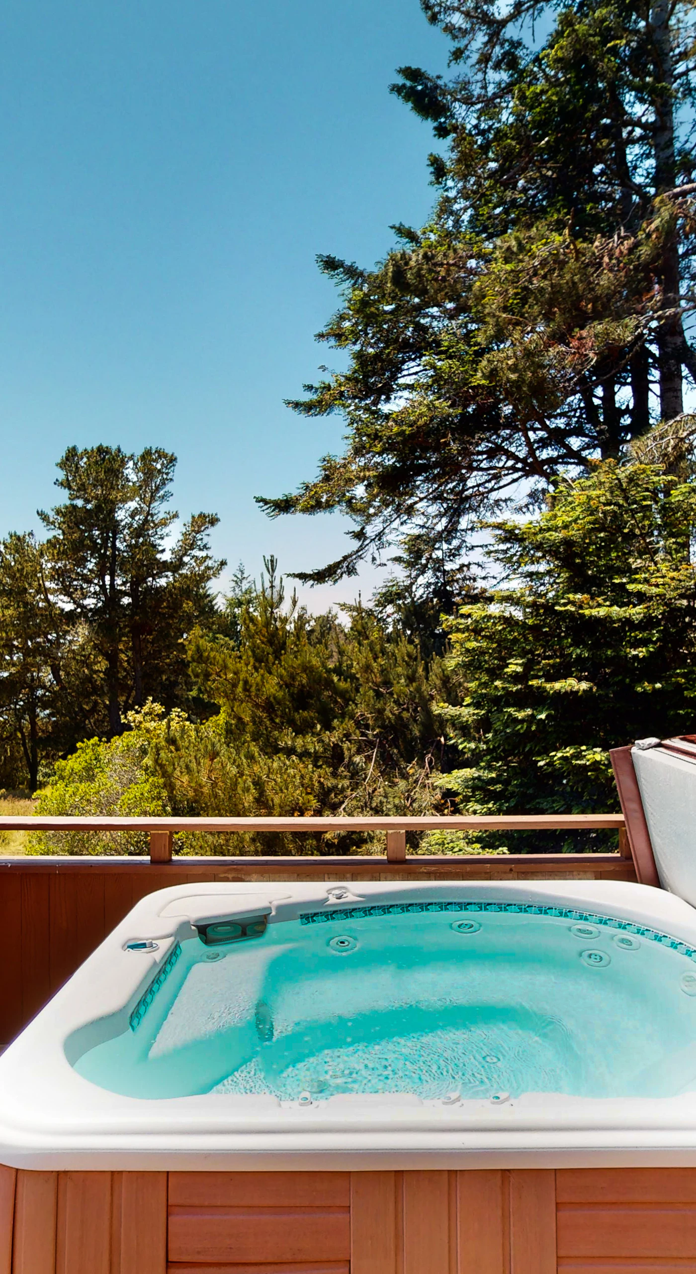 Soak in the hot tub while surrounded by serene nature, a perfect retreat after a day of exploring the stunning coastline.