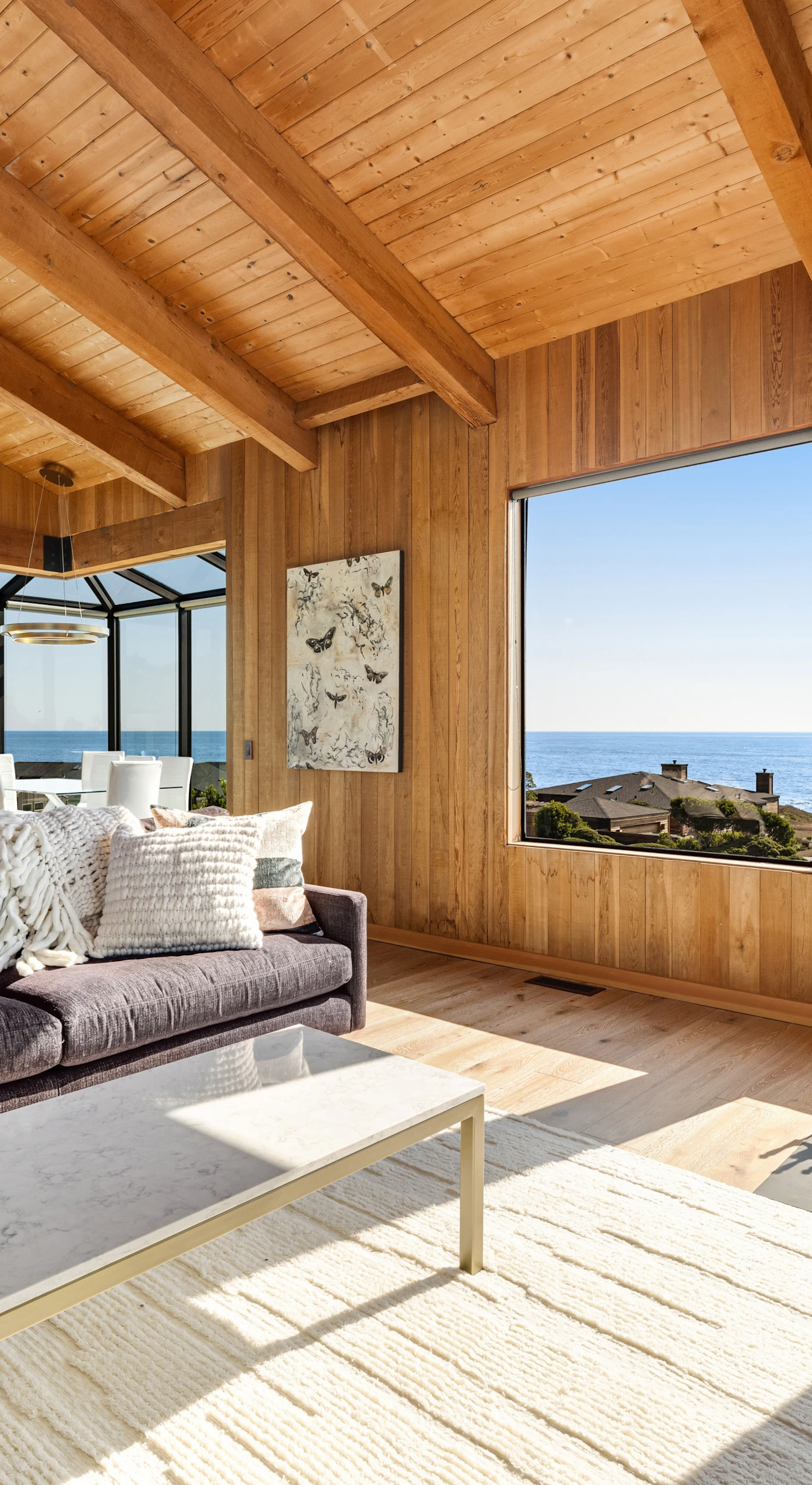 Relax and unwind in this inviting living room, where the ocean view and warm wood accents create a serene retreat.