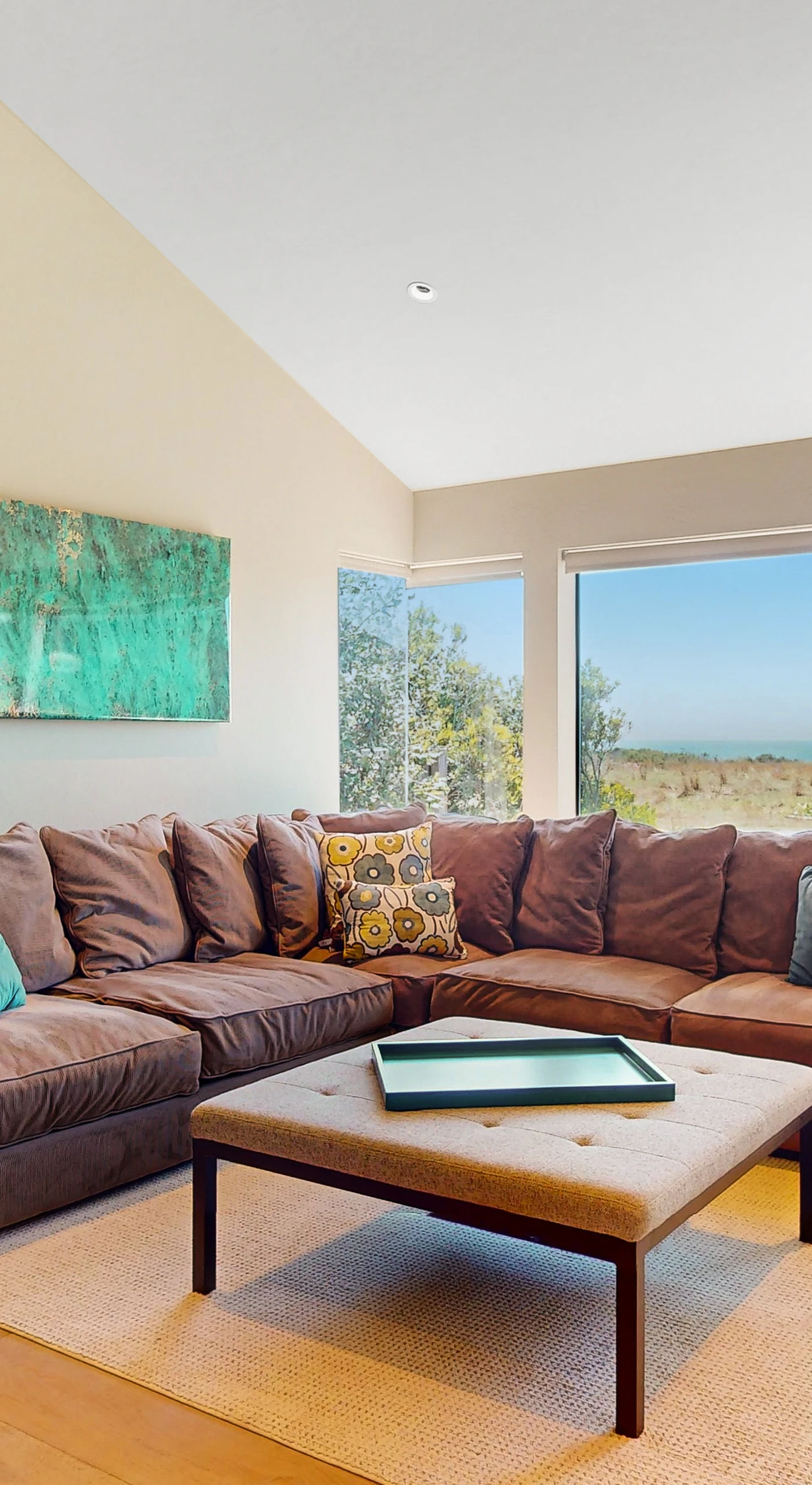 Gather your loved ones in this cozy living room, where natural light floods in and the ocean view sets the perfect backdrop.