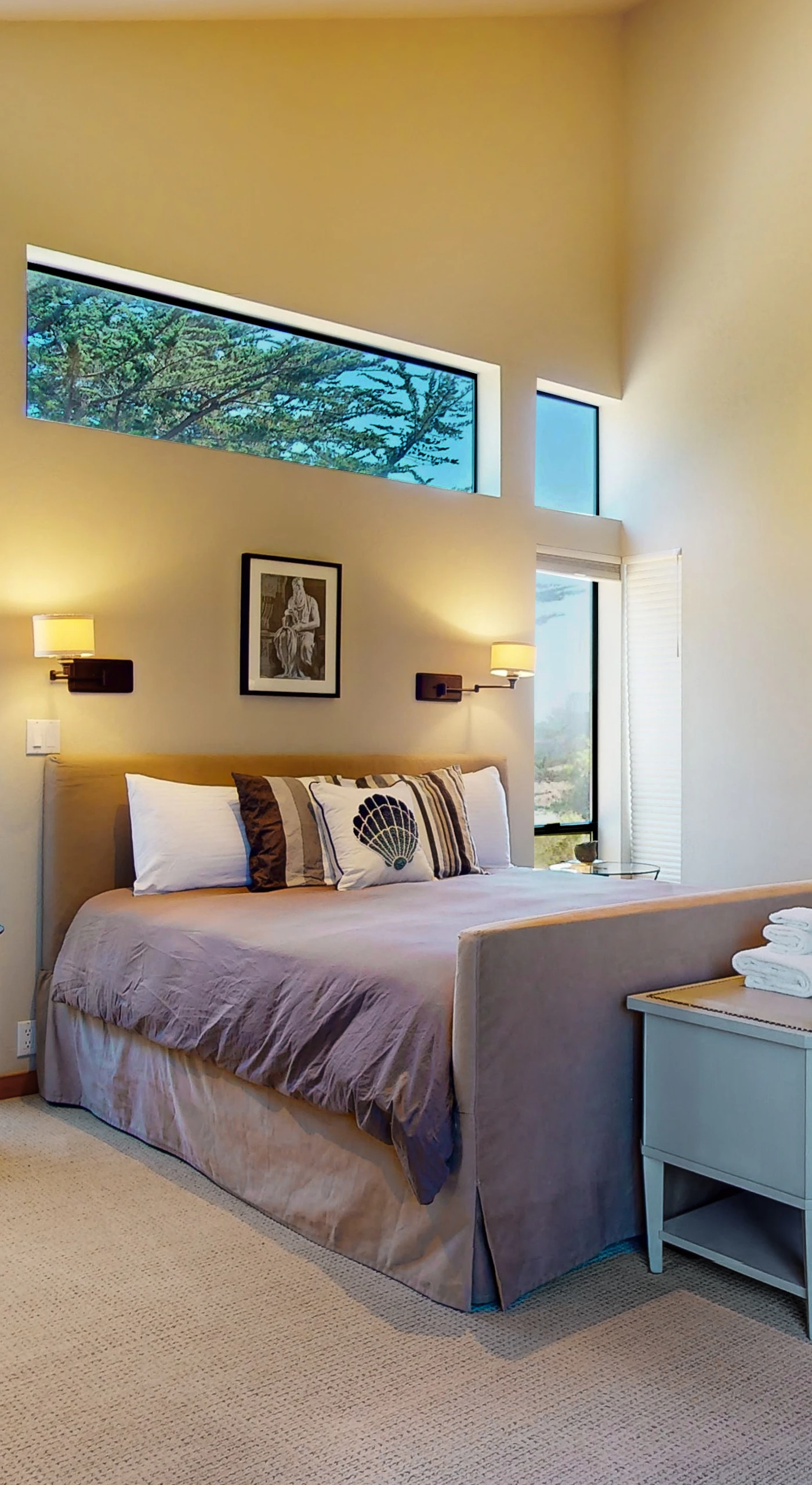 Your serene escape awaits in this master bedroom, where natural light and plush bedding promise restful nights after coastal adventures.