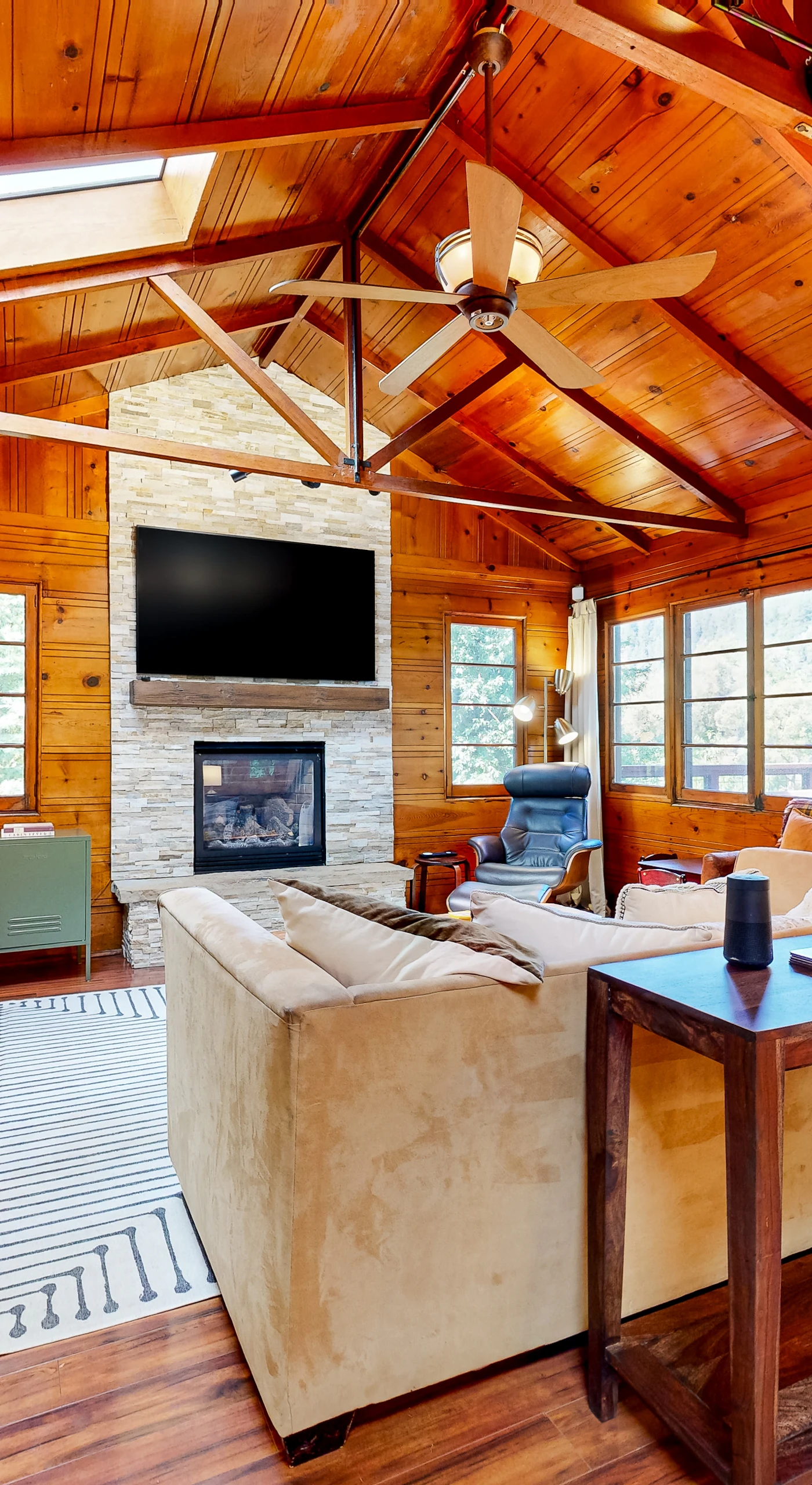 Settle into your warm, wood-paneled great room — vaulted knotty-pine ceilings, a stone fireplace, and flat-screen TV set the scene for wine country evenings along the Russian River.
