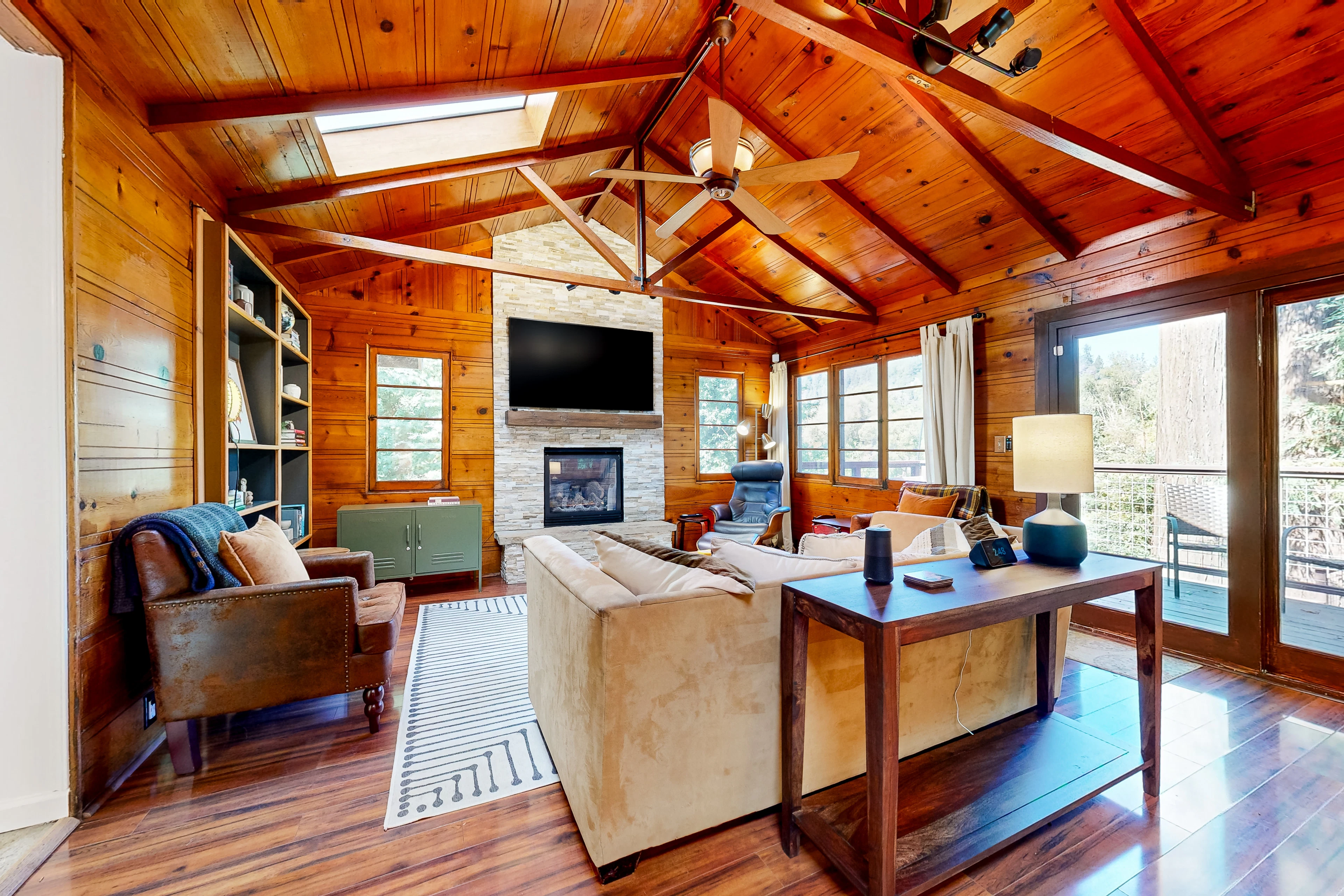 Settle into your warm, wood-paneled great room — vaulted knotty-pine ceilings, a stone fireplace, and flat-screen TV set the scene for wine country evenings along the Russian River.