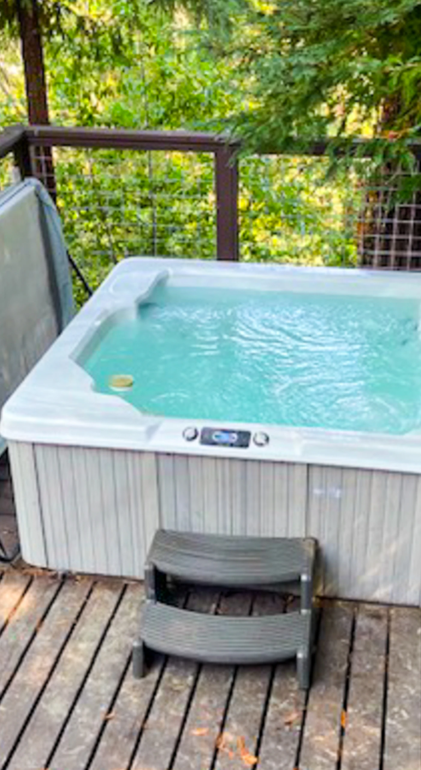 Slide into your bubbling private hot tub on the redwood deck — stars peek through the canopy as you recap your Forestville winery visits.