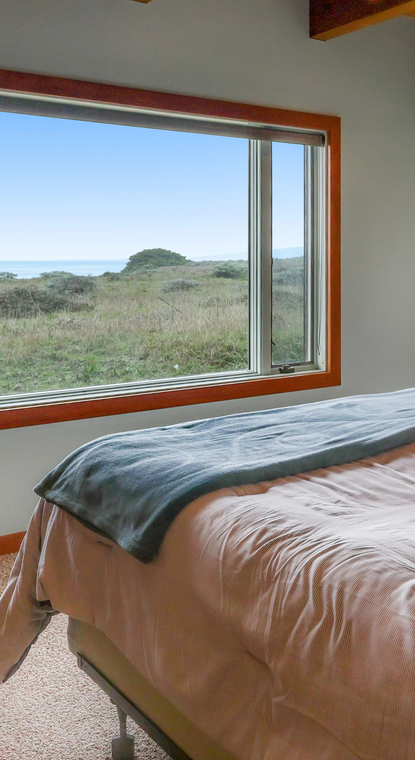 Awake to stunning coastal views in the primary bedroom, a peaceful retreat designed for relaxation and rejuvenation.