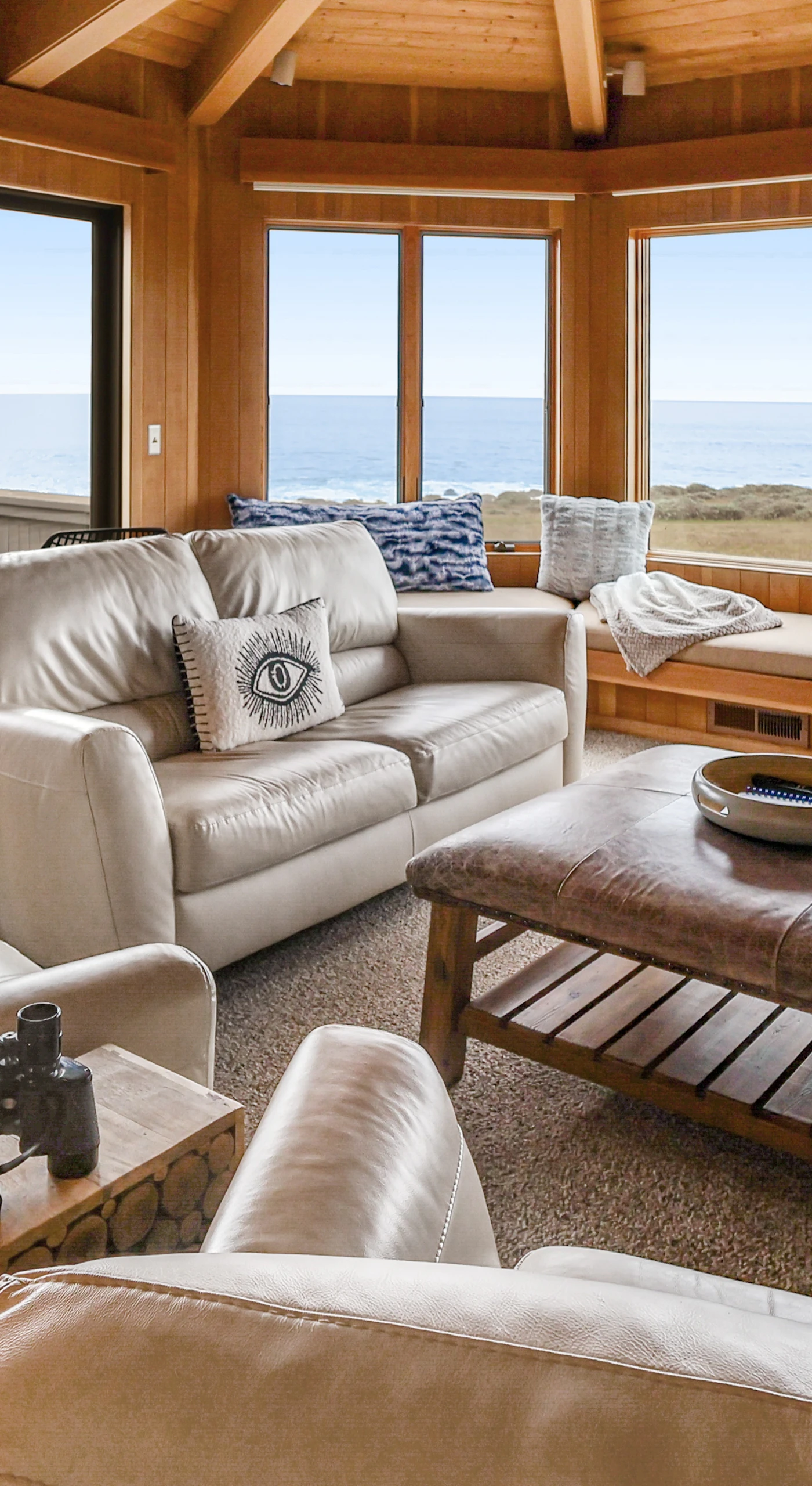 Gather around the wood-burning fireplace in this inviting living room, where panoramic ocean views set the stage for unforgettable moments.