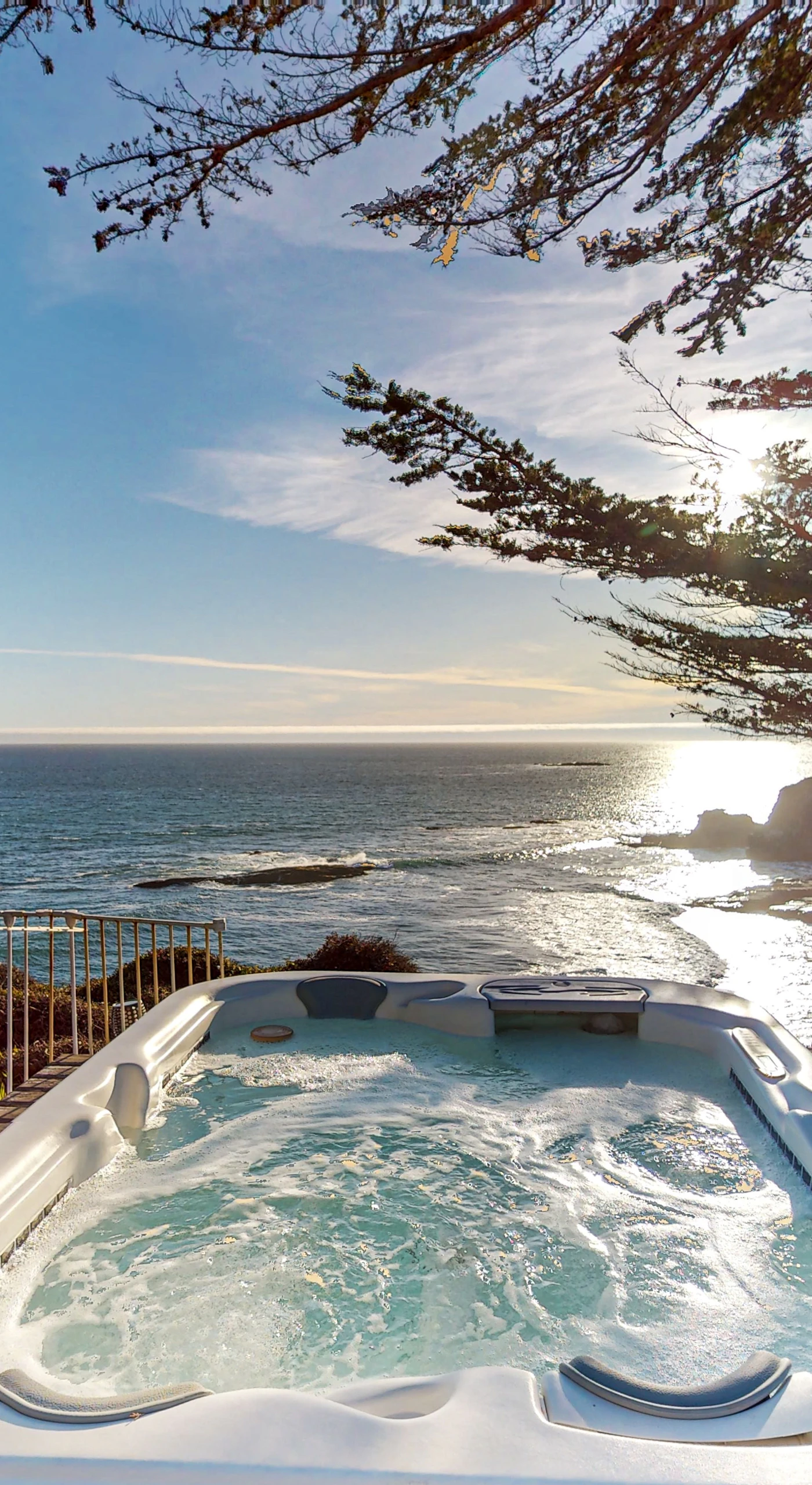 Soak in the private hot tub while watching the sun dip below the horizon, creating a magical coastal experience.