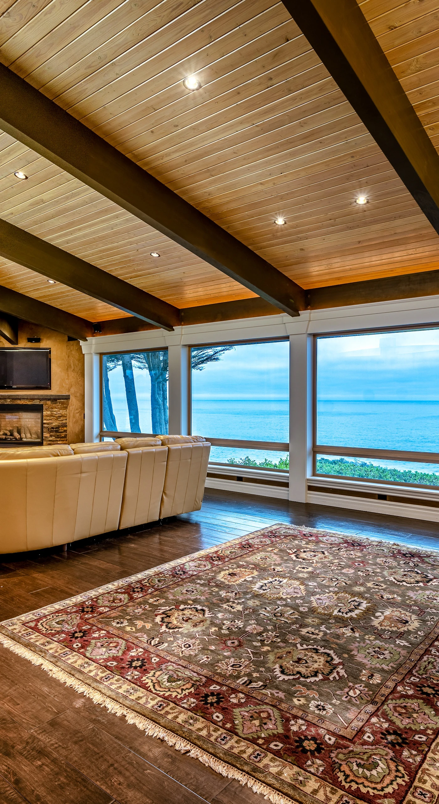 Imagine gathering with loved ones in this spacious living room, where floor-to-ceiling windows frame breathtaking ocean views.